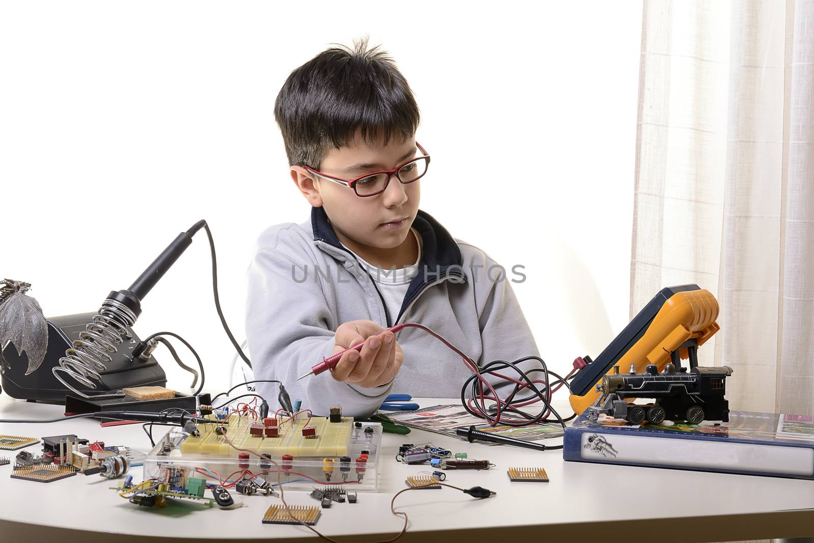 Young student performs experiments in electronics and dreams of the future.