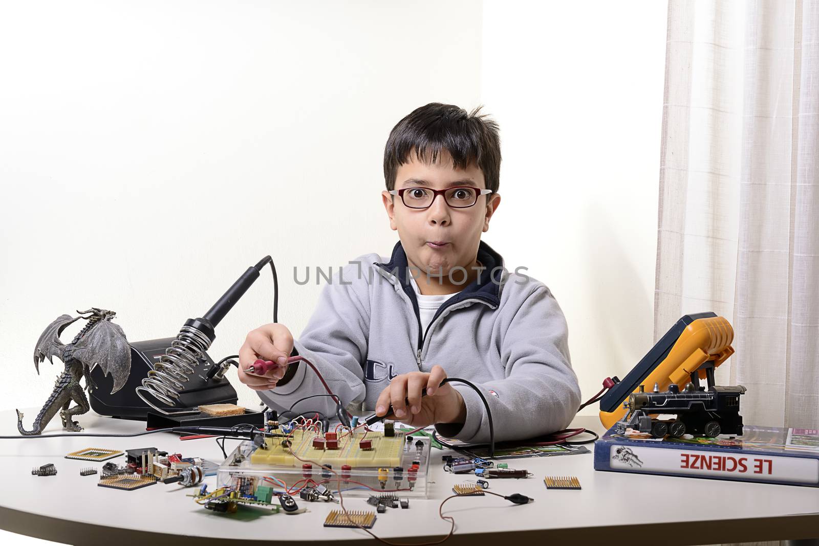 Young student performs experiments in electronics and dreams of the future.