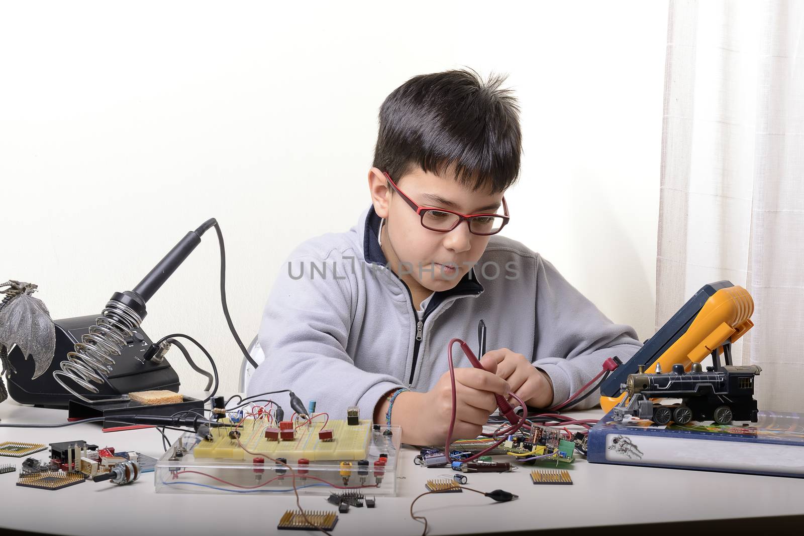 Young student performs experiments in electronics and dreams of the future.