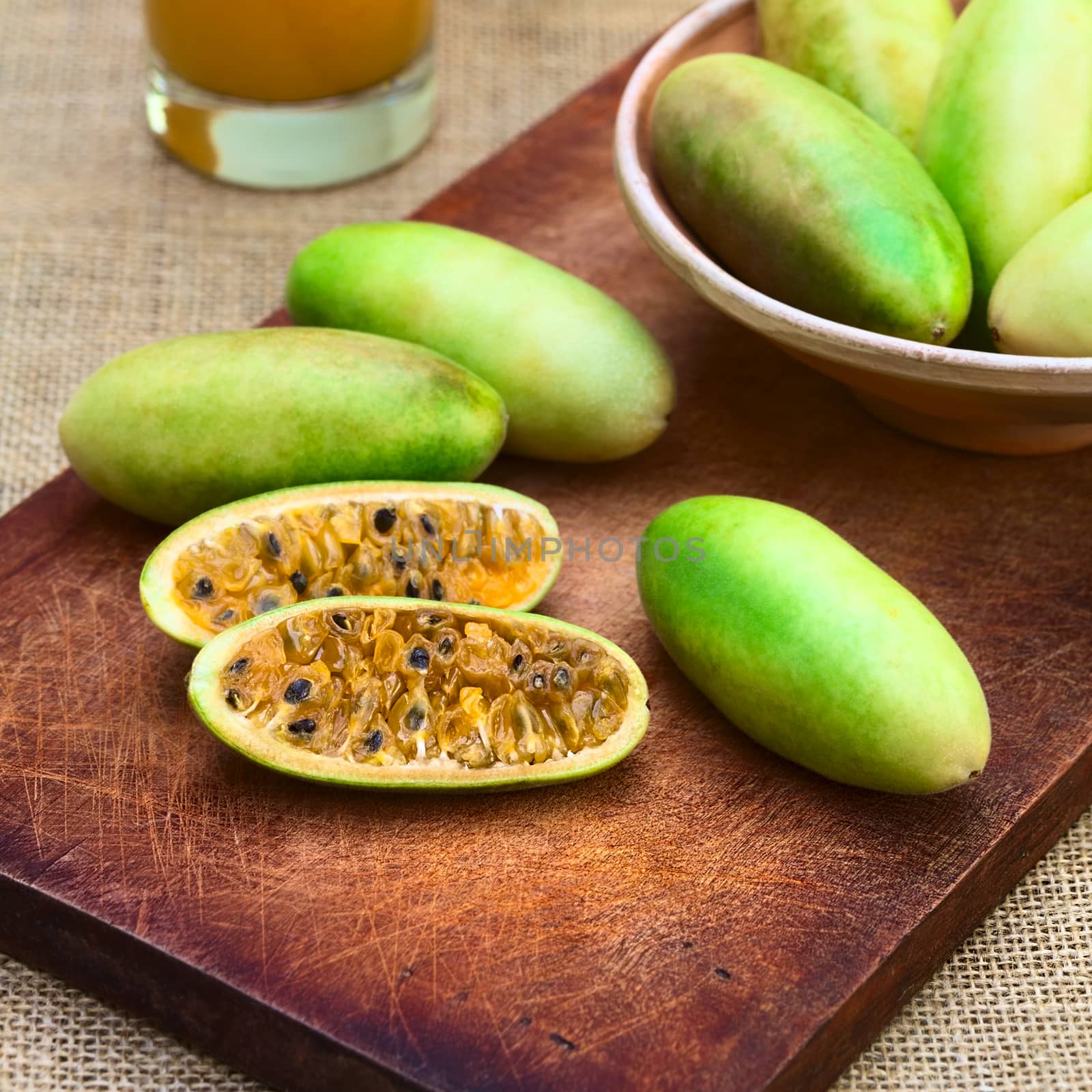 Latin American fruit called banana passionfruit (lat. Passiflora tripartita) (in Spanish mostly tumbo, curuba, taxo) cut in half which is mainly used to prepare juice (Selective Focus, Focus on the fruits in the front)