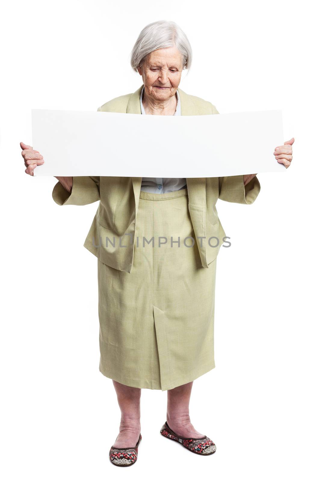 Happy elderly lady holding blank sheet in hands by photobac
