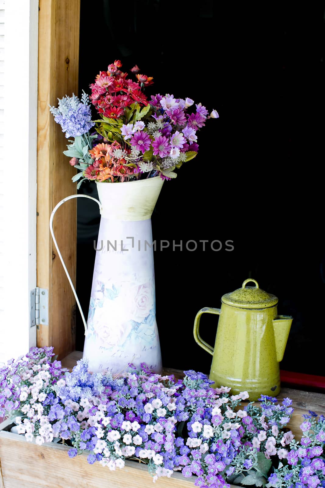 Beautiful flowers in white jug on wooden window