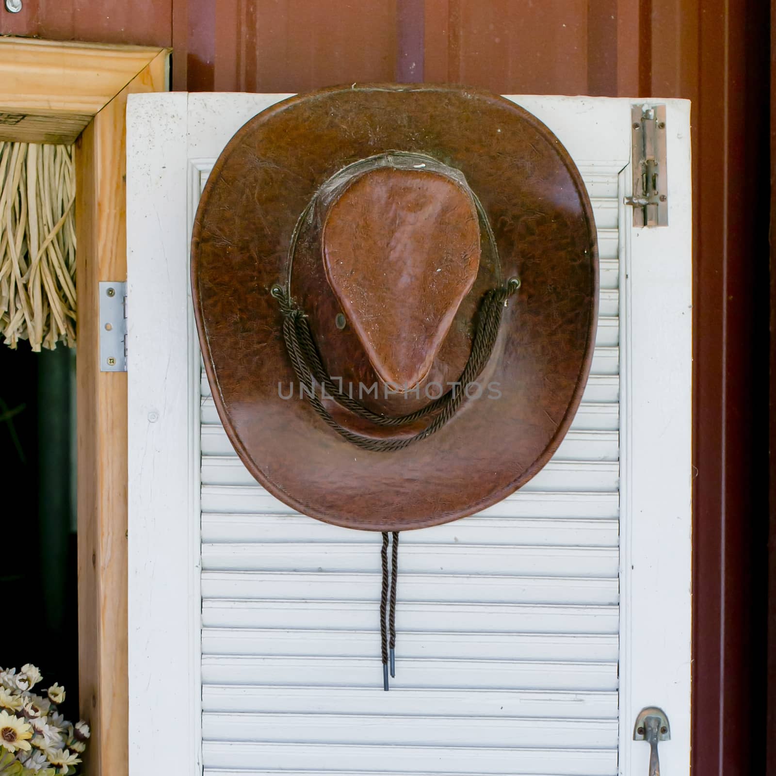 cowboy hat hanging on a wooden door