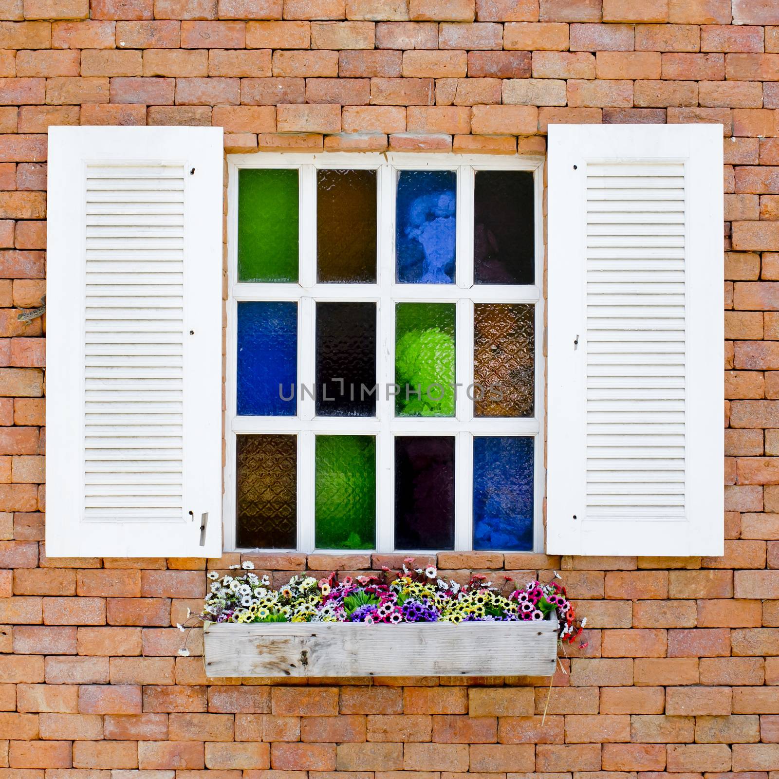 Brick Wall with colorful glasses in White Window and beautiful flowers