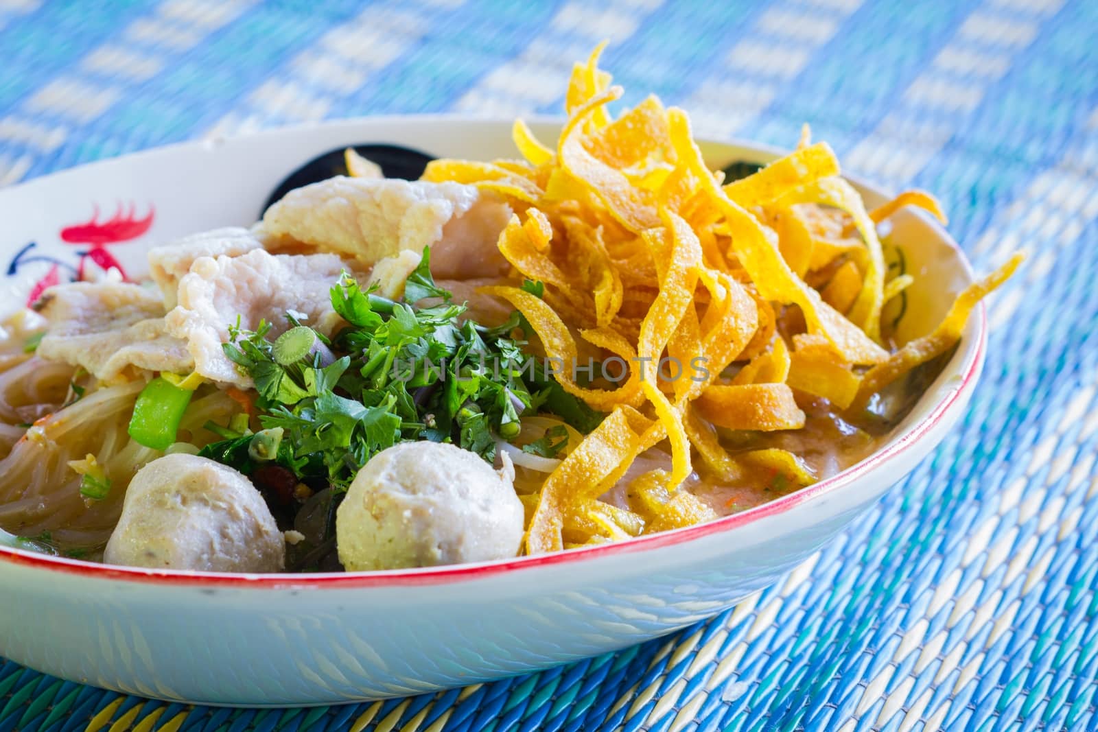 Thai food.noodle soup with fish ball and pork on blue mat by a3701027