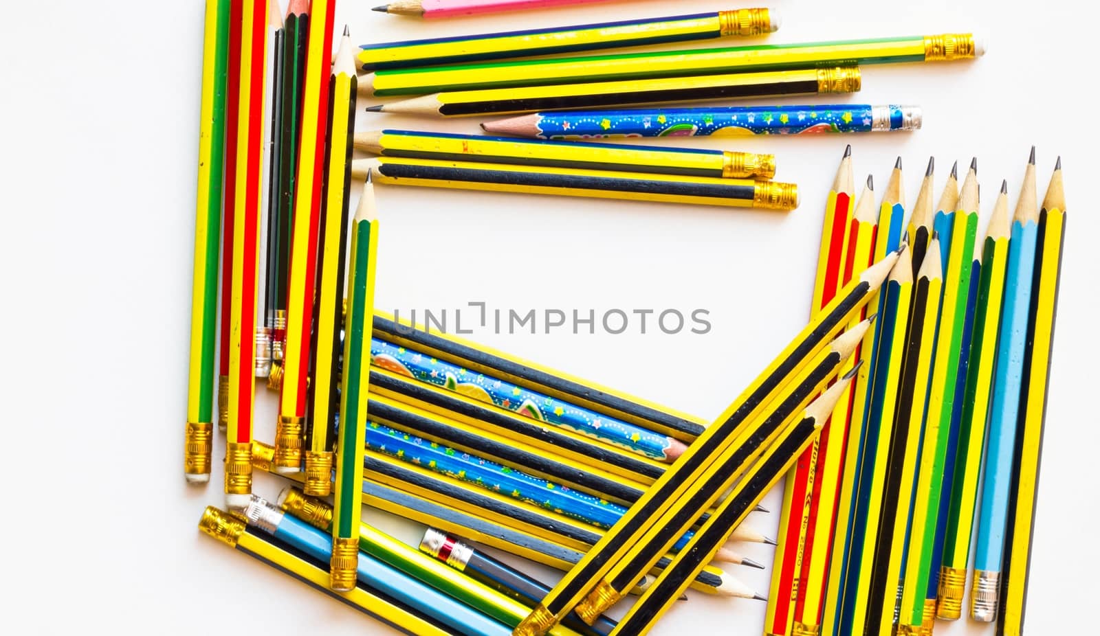 colorful pencils on the white paper, view from above, close-up