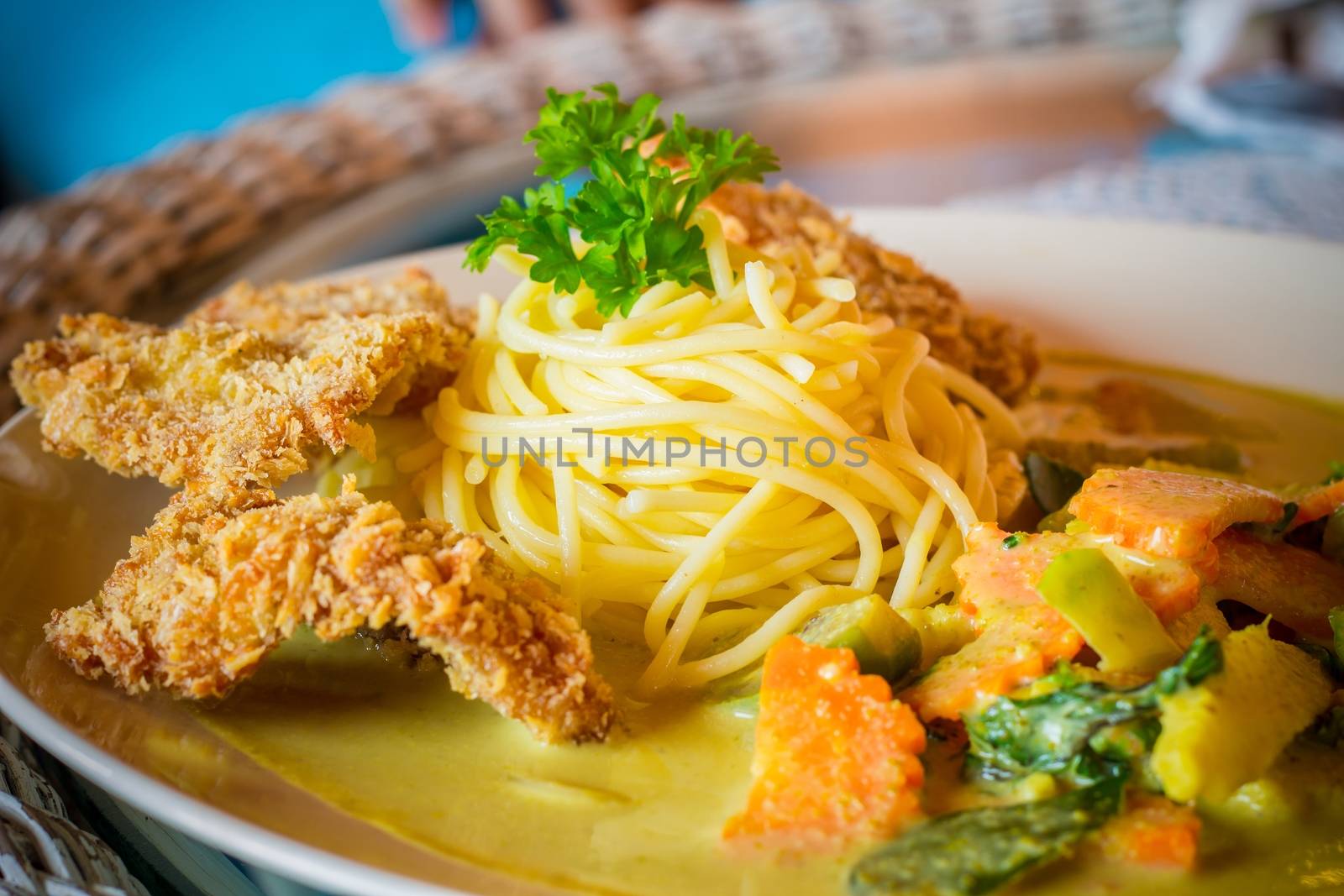 close-up of spaghetti green curry with fried pork on tabl, thai style