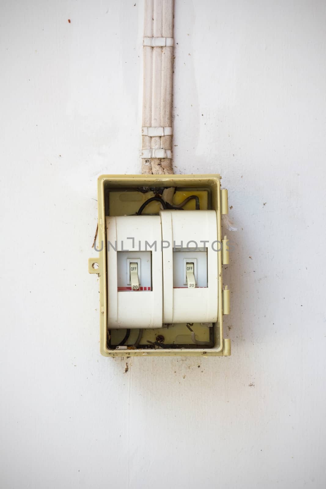 old light switch in the Off Position on dirty and old wall.