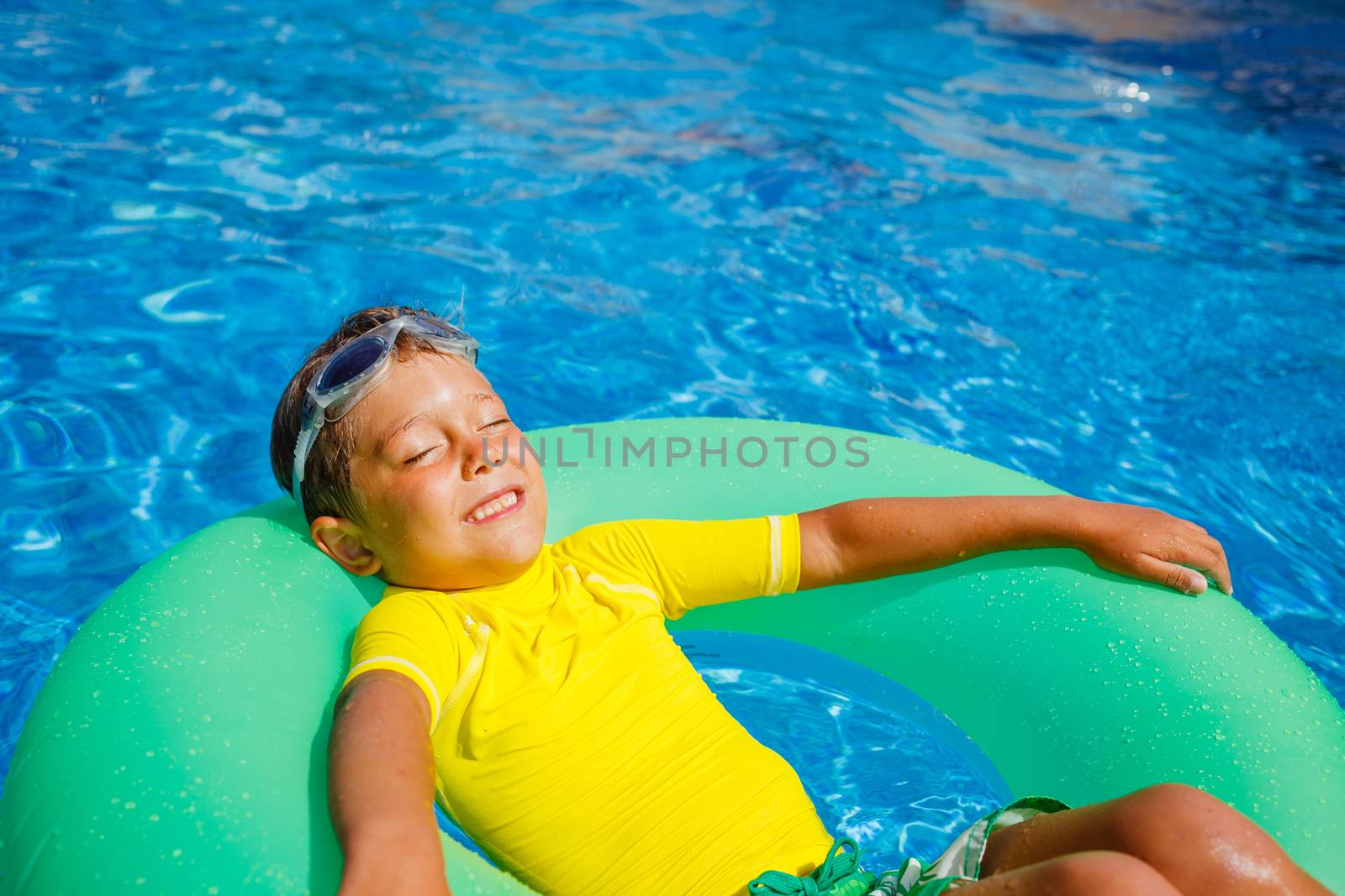 Boy swims in a pool by maxoliki