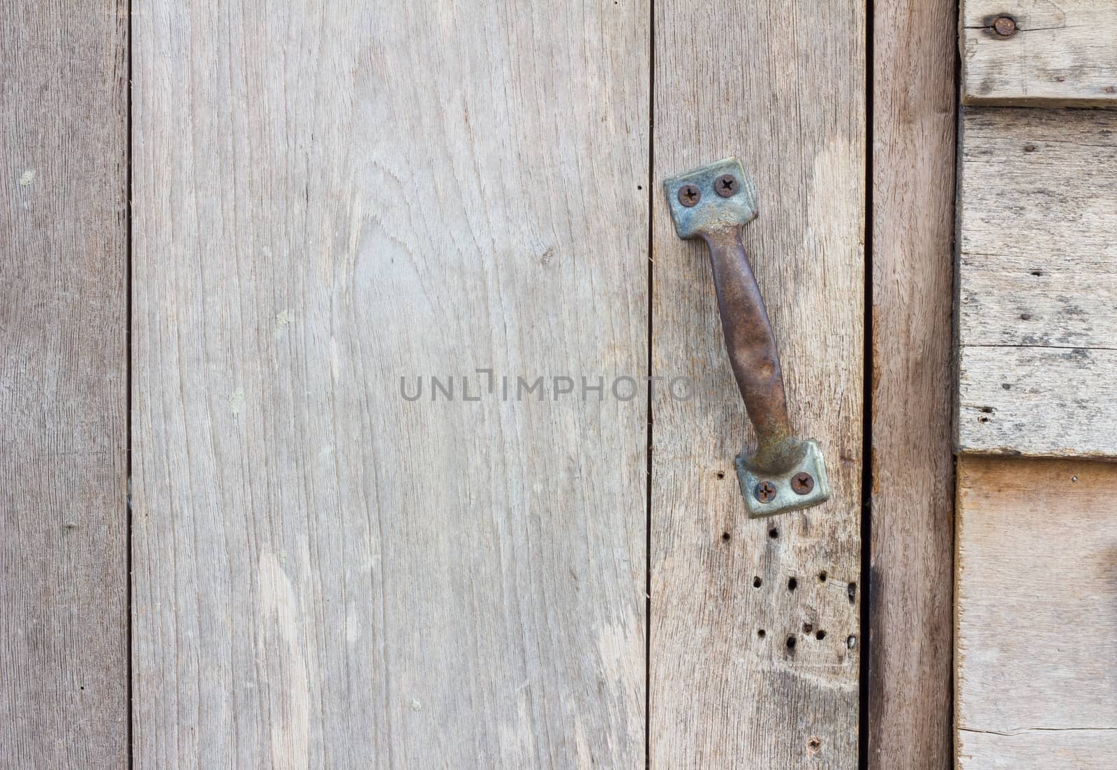 grungy brown wood plank wall texture background, with old rusty door handle

