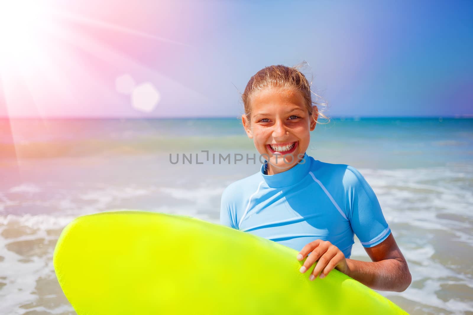 Teenage girl in blue has fun surfing