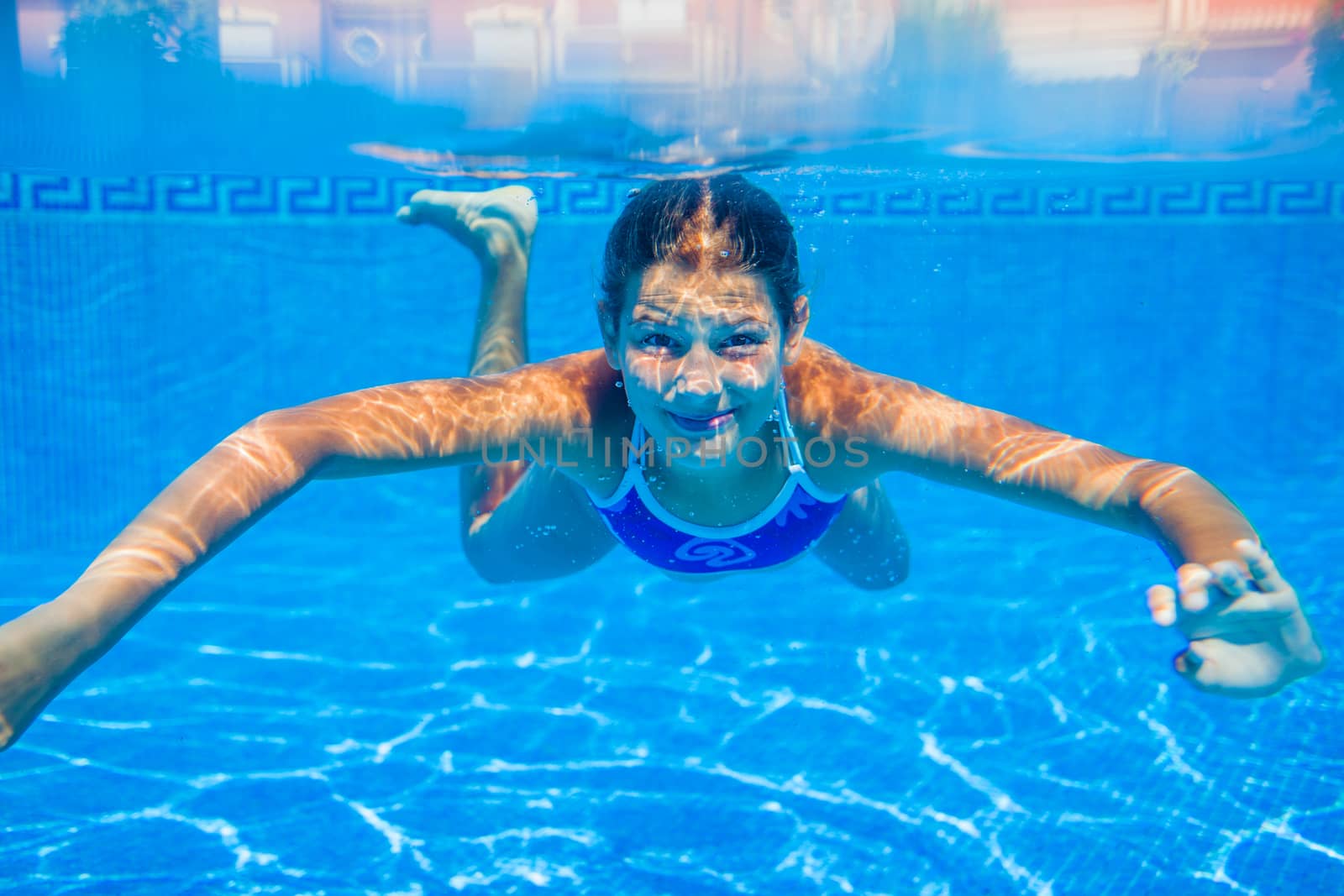 Underwater happy cute girl in swimming pool