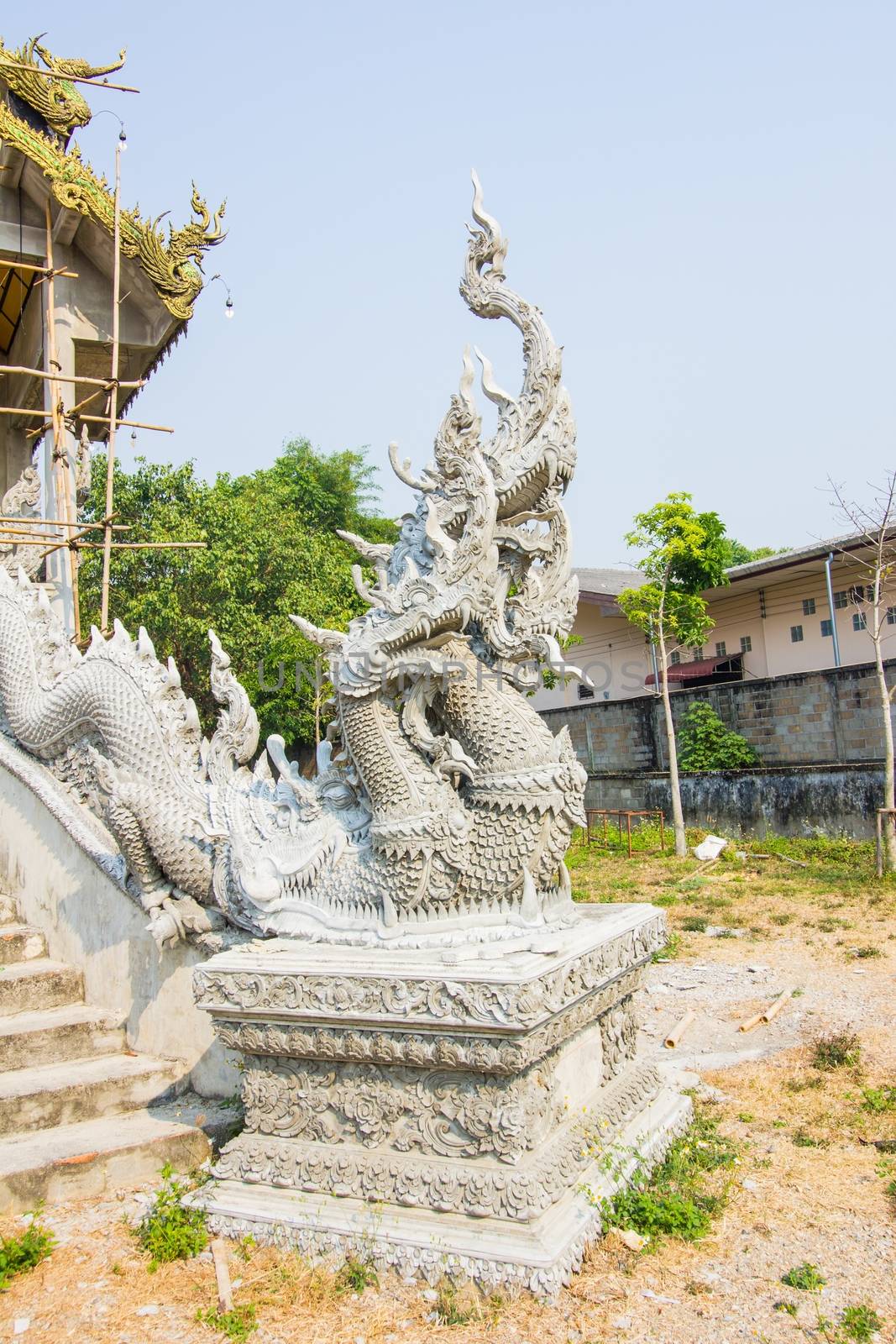 unfinished naga statue beside the stairs in Thai temple.