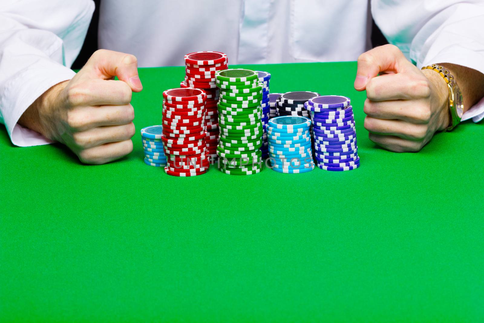 Man with a bunch of chips. Green casino table