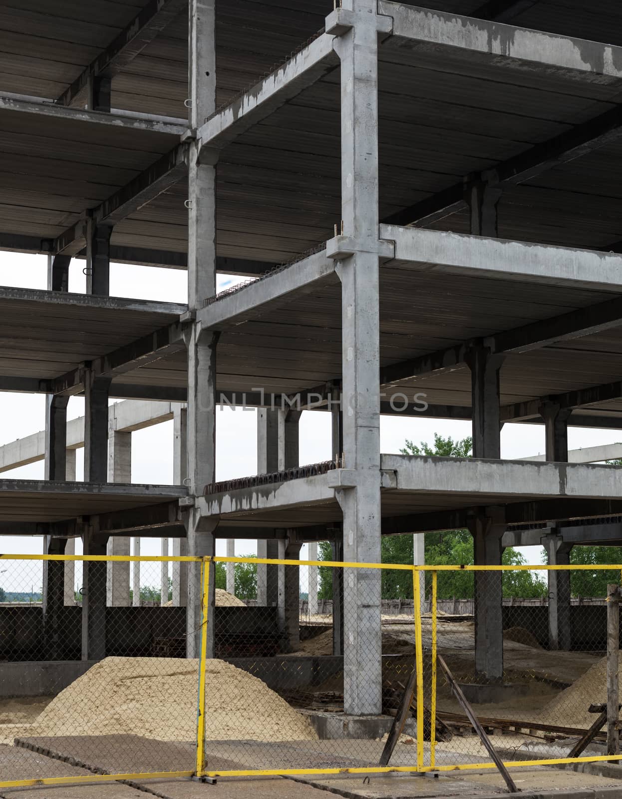 Unfinished grey concrete framework of the future building in the construction site