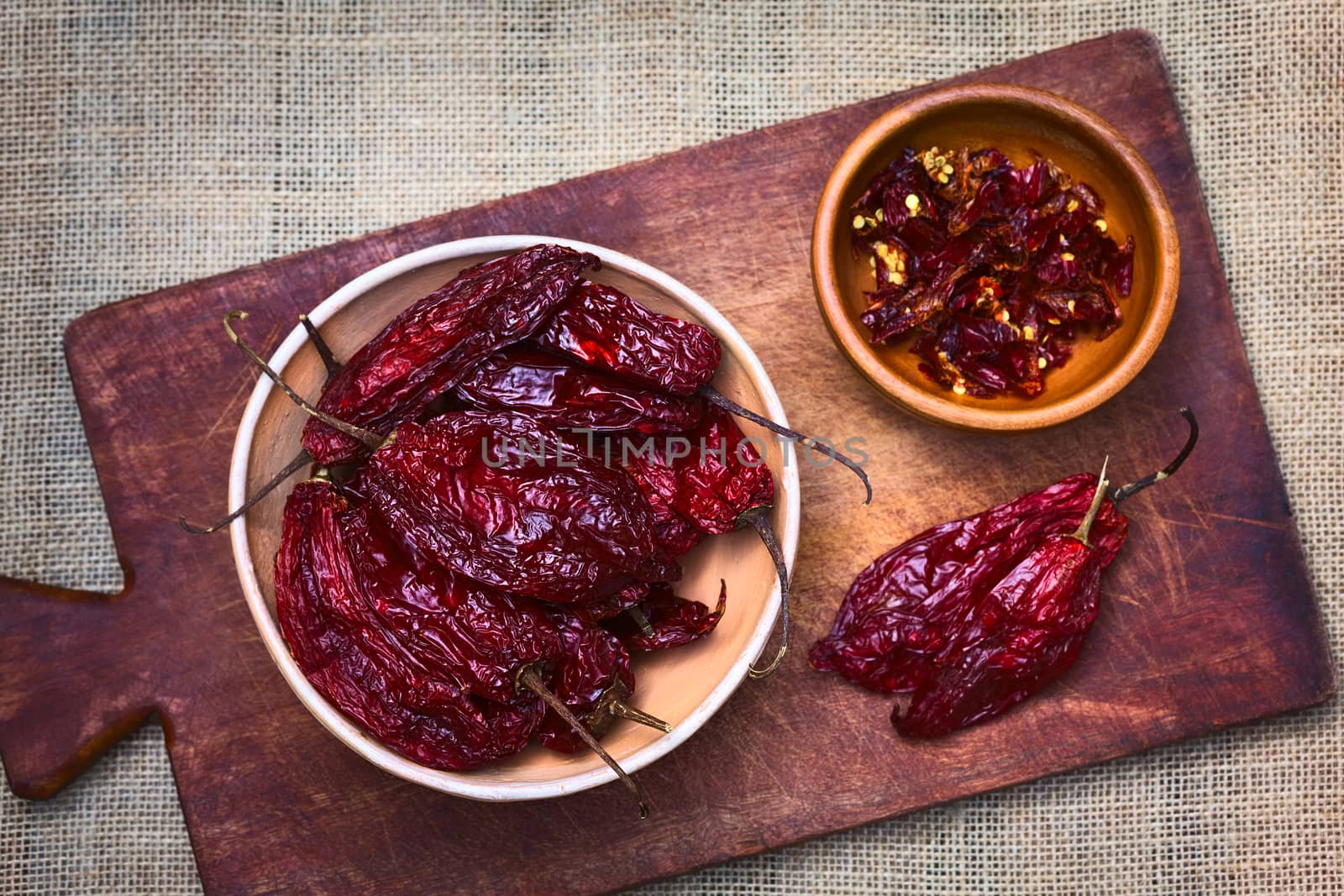 Bowl of dried (slightly hot) red aji chili pepper found in Bolivia and used for seasoning photographed with natural light (Selective Focus, Focus on the peppers on the top in the bowl)