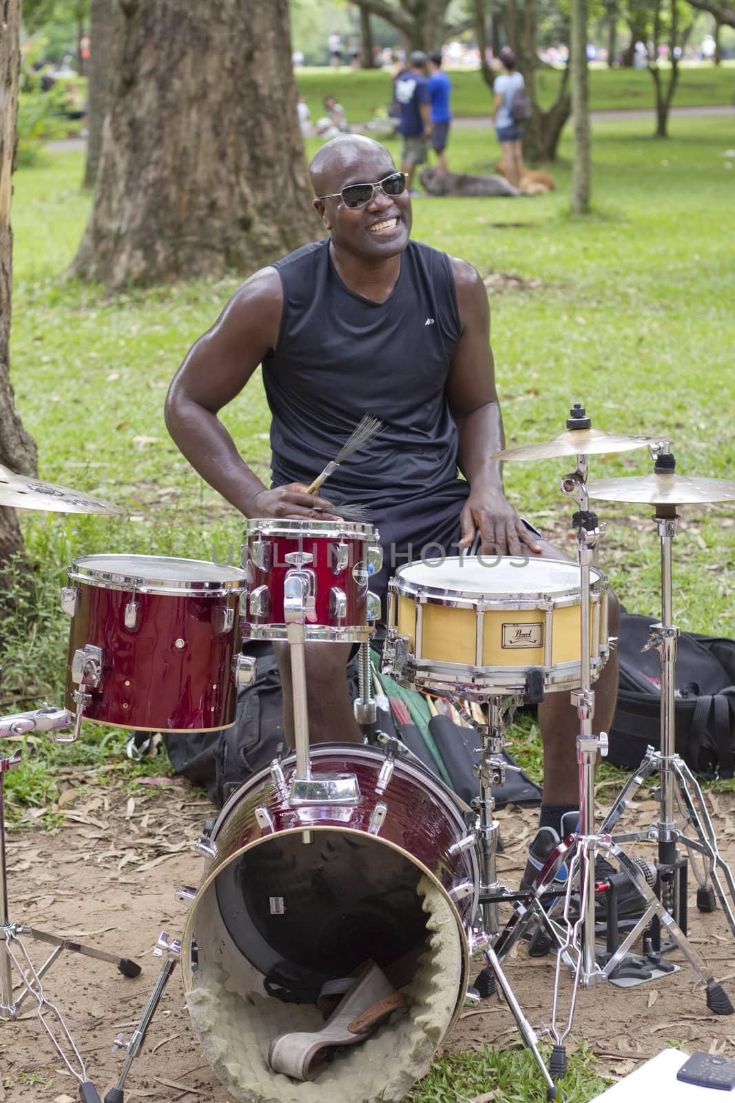 SAO PAULO, BRAZIL - FEBRUARY 01, 2015: An unidentified street musician singing and playing drums in the Ibirapuera Park at Sao Paulo Brazil.