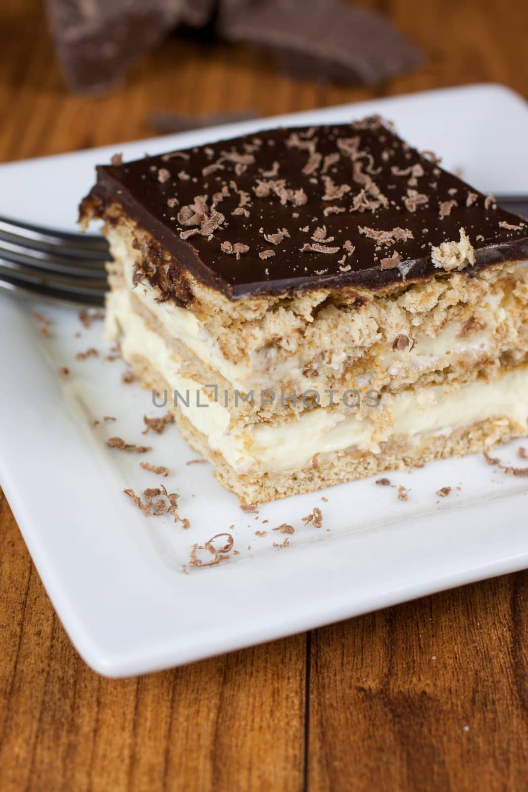 A layered Boston creme pie style dessert made with french vanilla filling and chocolate ganache topping.