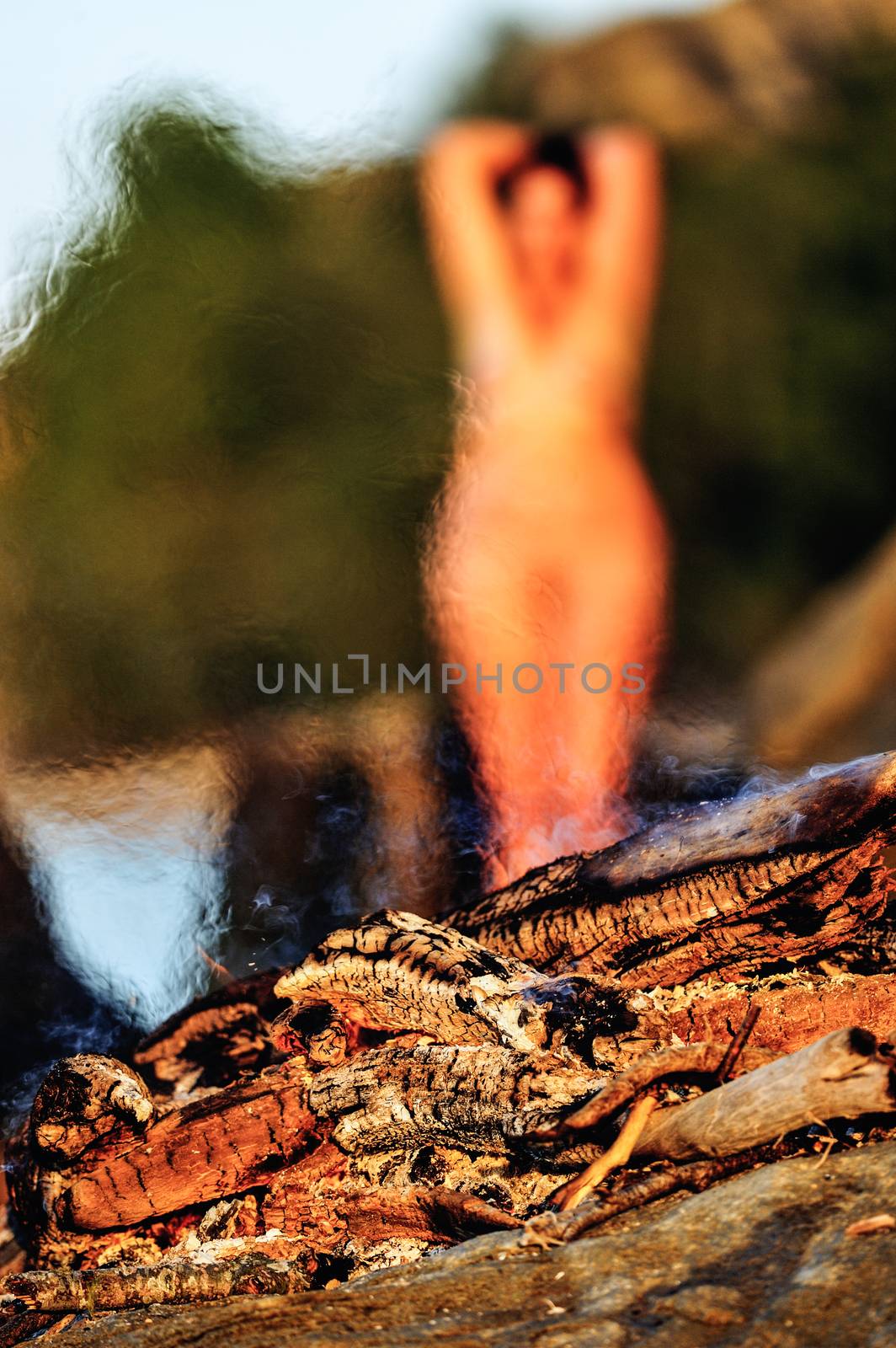 Nude woman on seashore near the bonfire