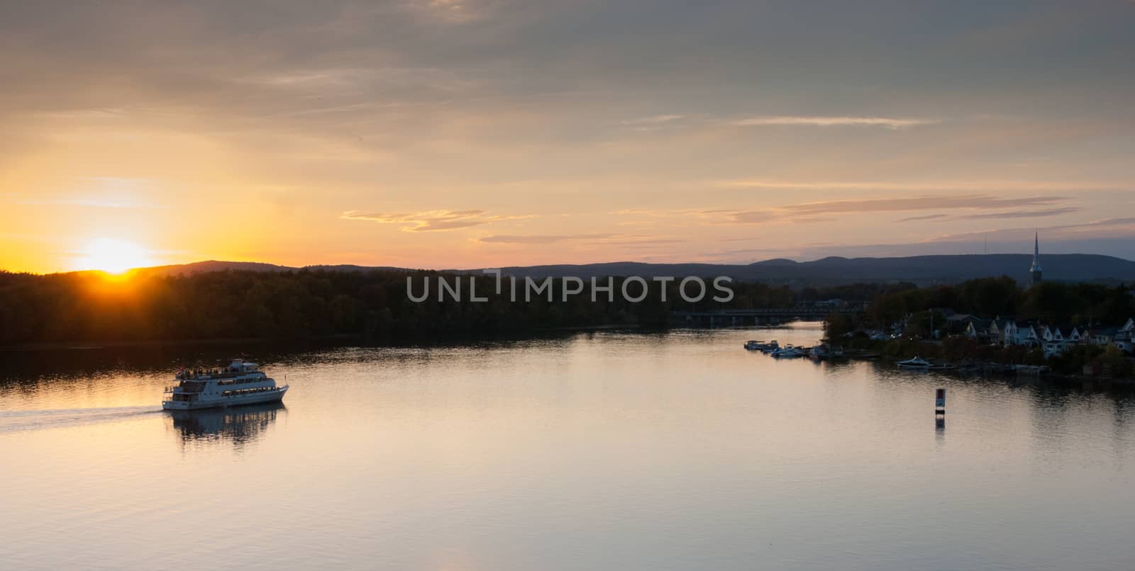 A riverboat of sight-seers cruise the river on a lovely warm summer evening