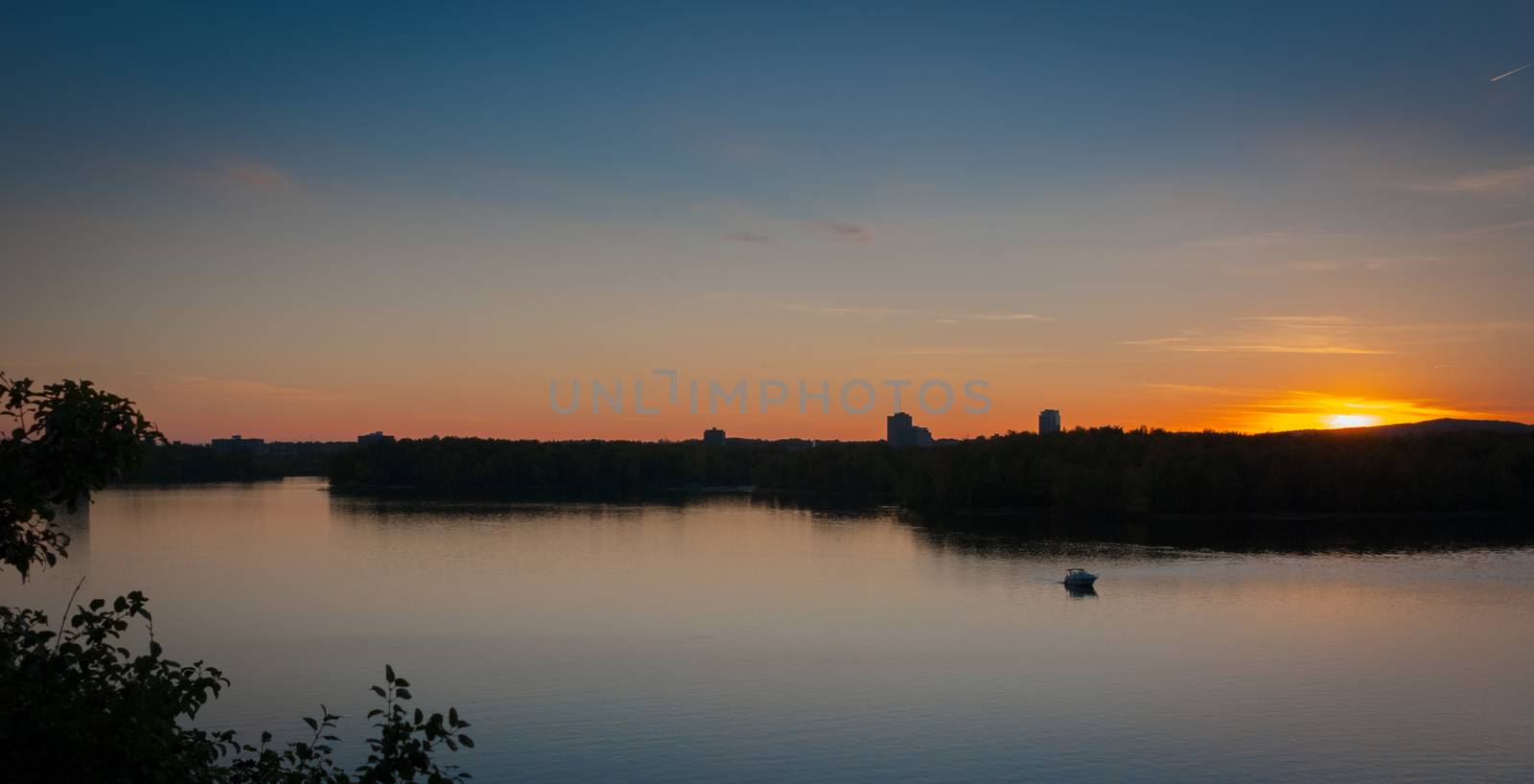 A riverboat of sight-seers cruise the river on a lovely warm summer evening