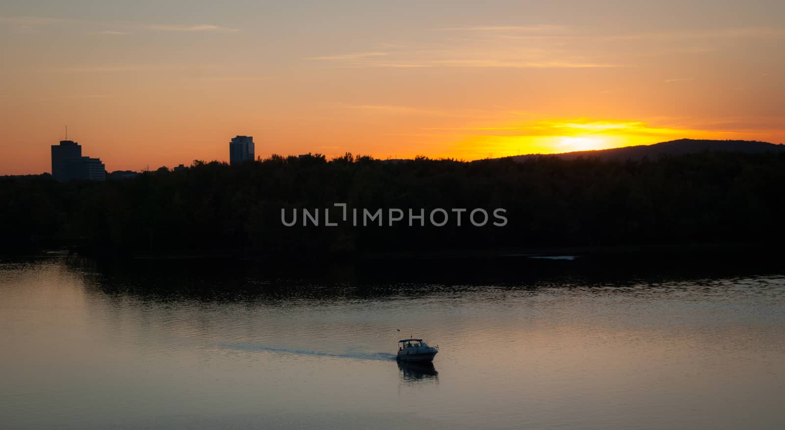 A riverboat of sight-seers cruise the river on a lovely warm summer evening