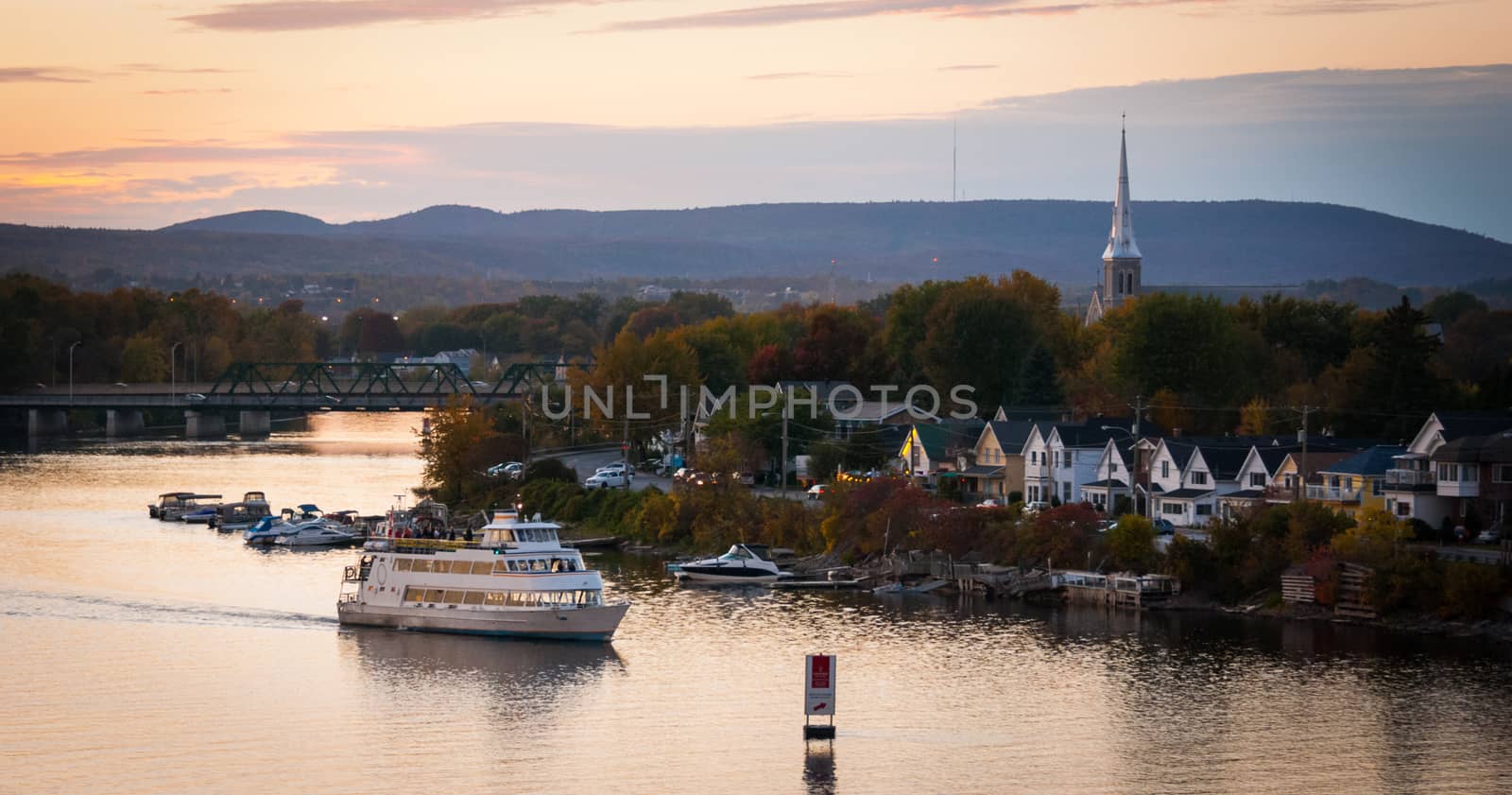 A riverboat of sight-seers cruise the river on a lovely warm summer evening