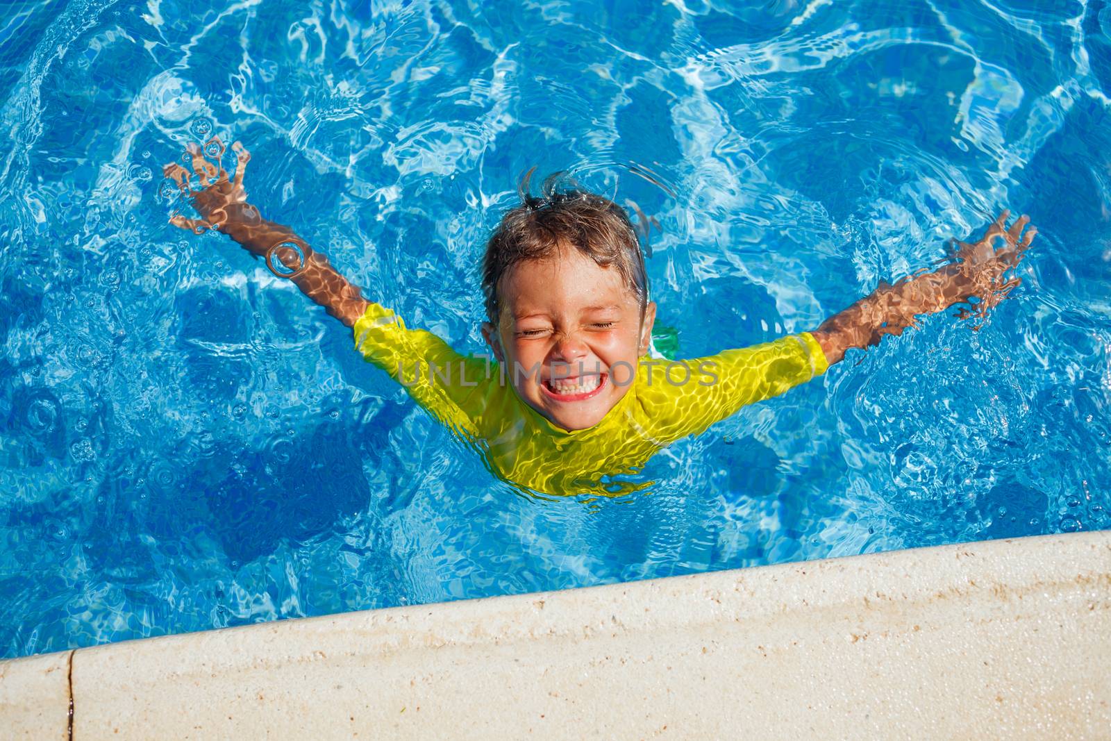 Cute happy little boy swimming and snorking in the swimming pool