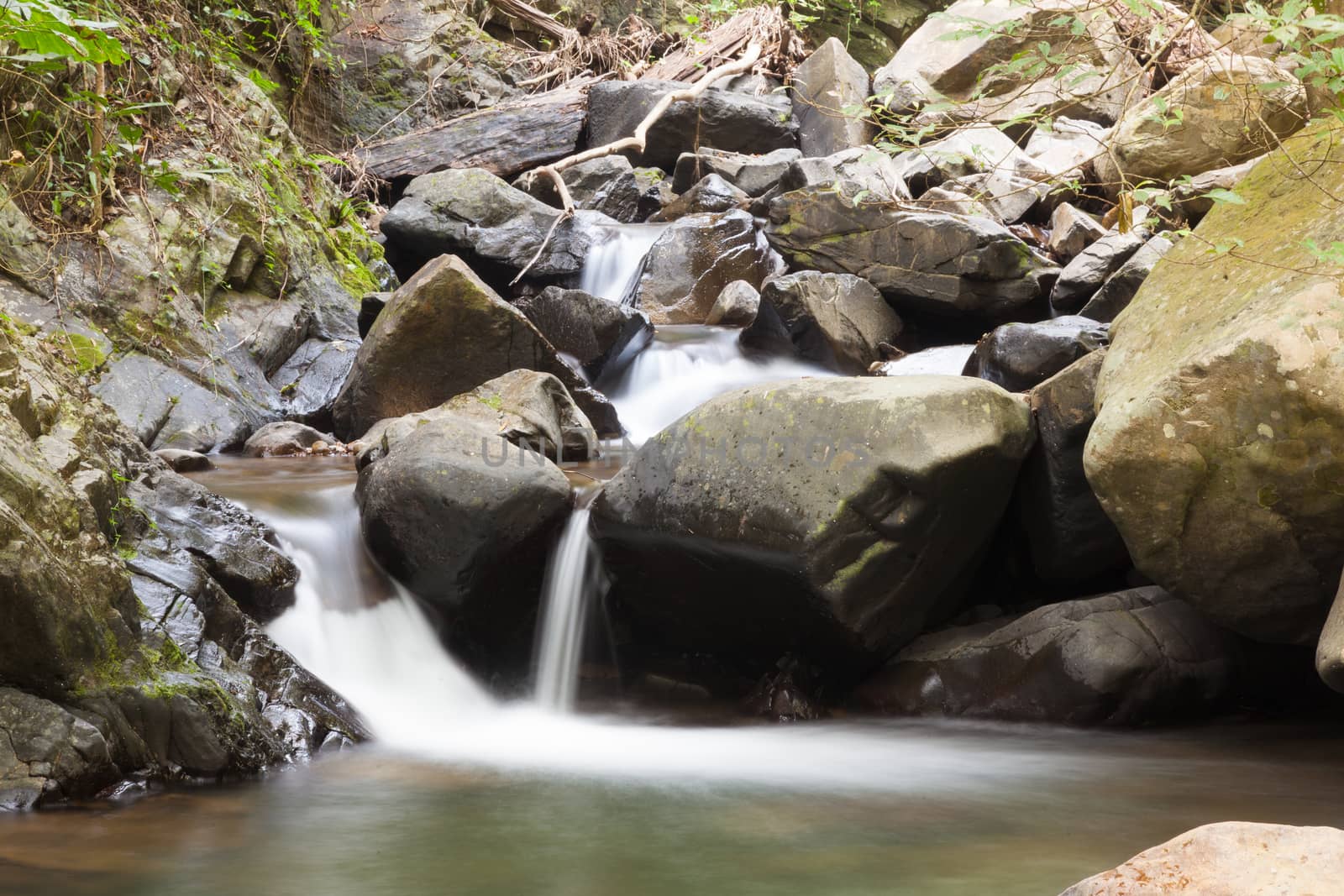 Waterfall that flows down from the mountains. Streams of water flowing down from the mountains. There is always a small stone waterfall.