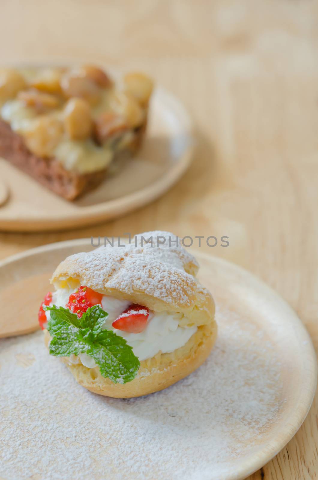 close up  strawberry Choux Cream  and macadamia cake on wooden dish