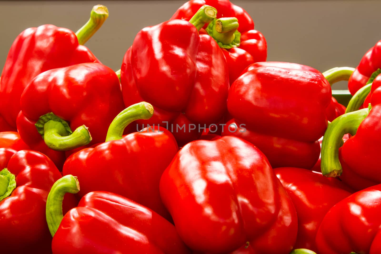 Ripe red bell peppers on the shelf in grocery store.