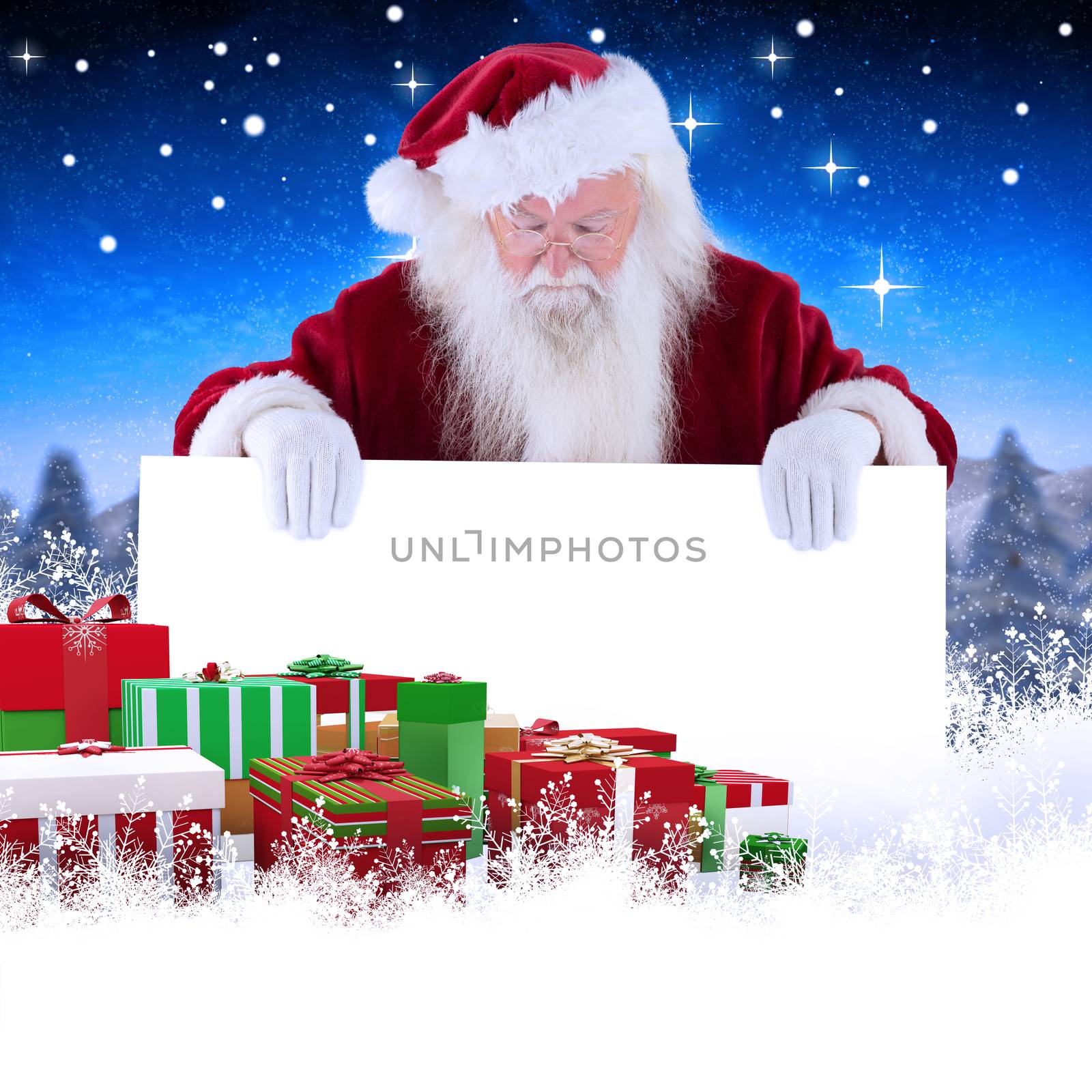 Composite image of santa holds a sign and looks down by Wavebreakmedia