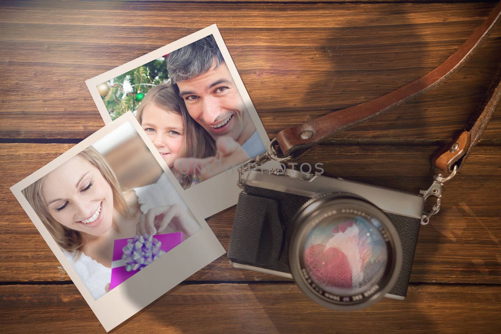 Composite image of christmas memories against instant photos on wooden floor