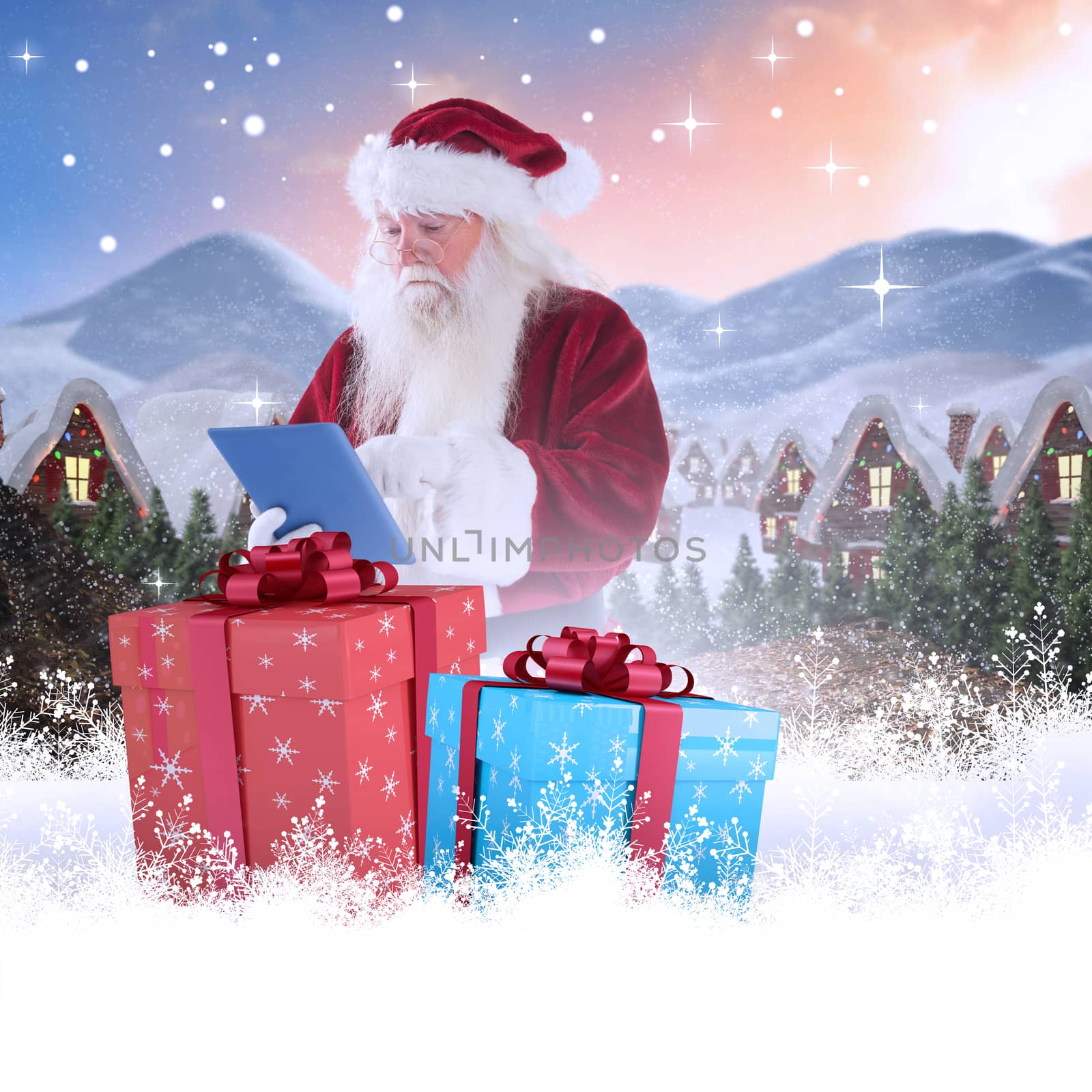 Santa uses a tablet PC against cute village in the snow