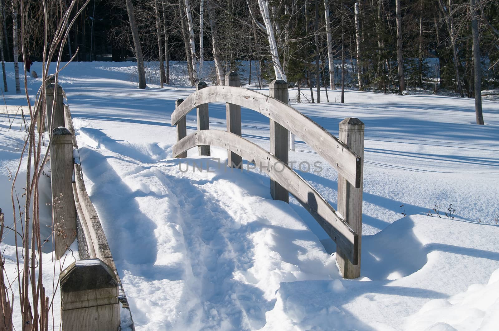 Footbridge in the winter with a path in the snow
