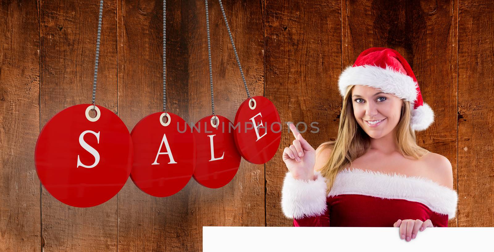 Composite image of festive blonde smiling and pointing by Wavebreakmedia