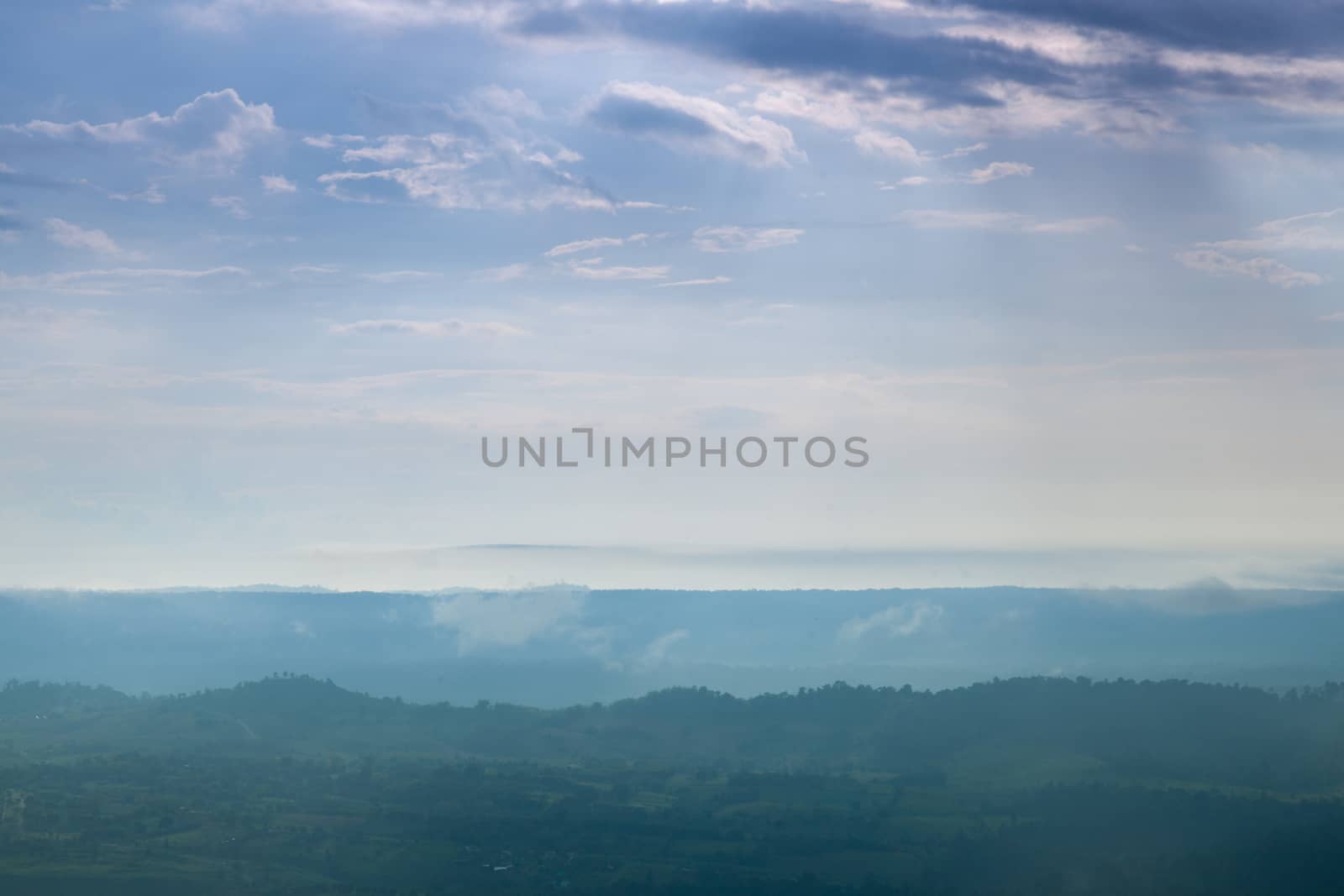 Forested mountains and sky. A slight mist-shrouded mountains and trees. Clear sky