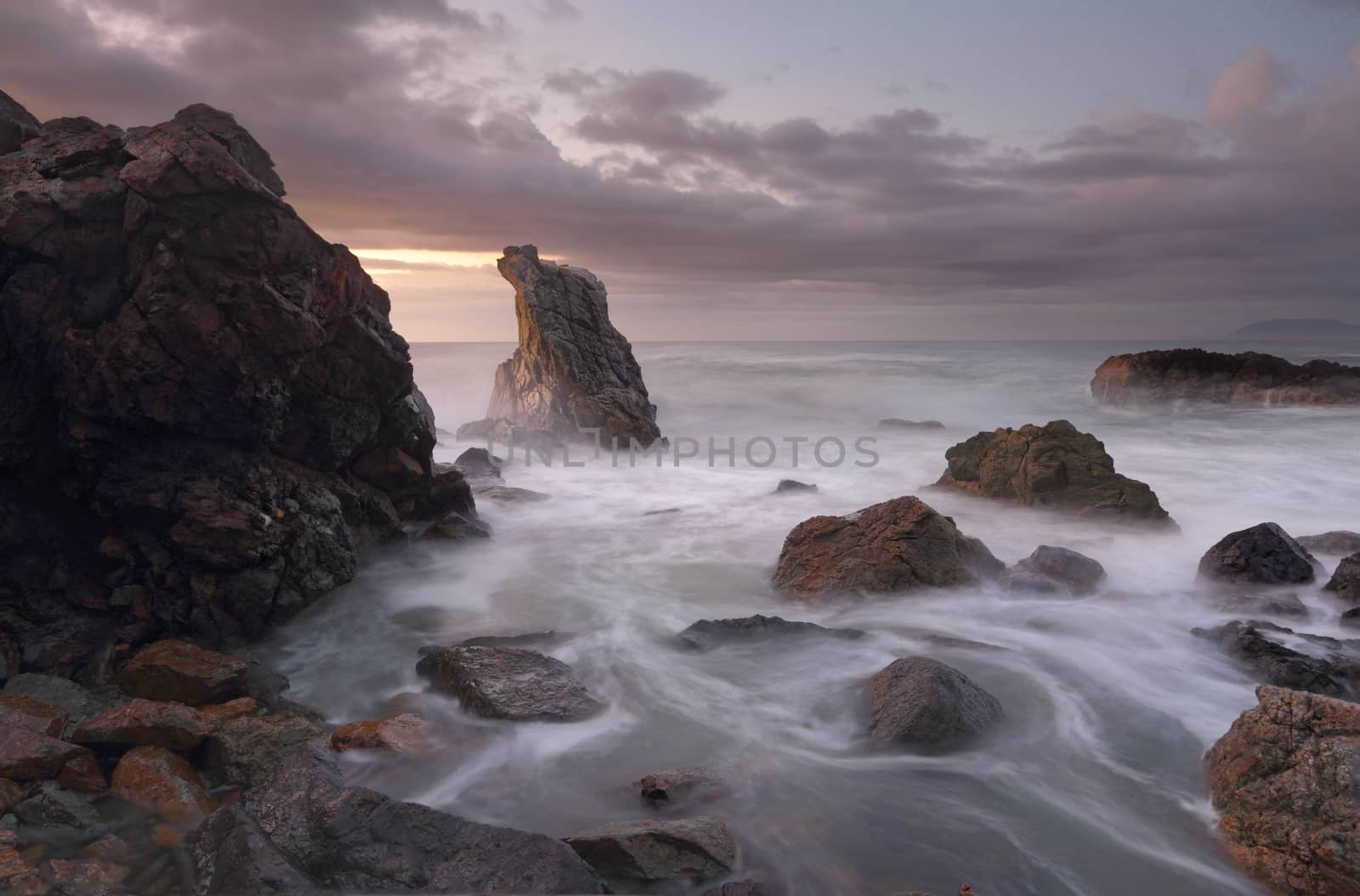 Soft and subtle hues of dawn and a rising tide around the rocks at Lighthouse Beach, Port Macquarie