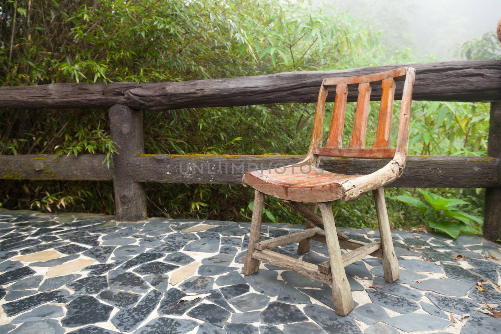 Wooden chair on the balcony. Decking made of stone The outside terrace is a tree of moist air.