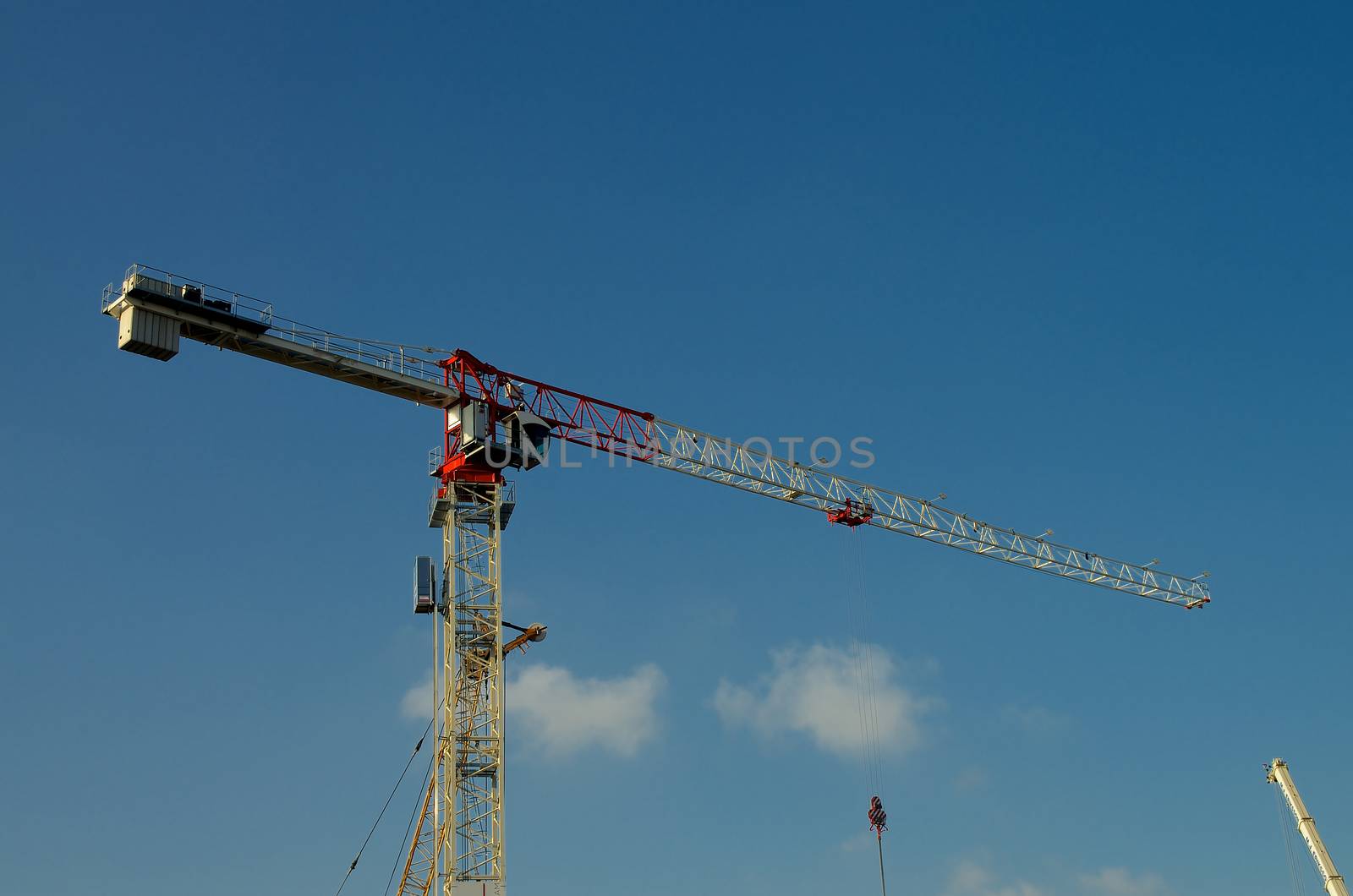 Construction Crane Towering with Construction Details against Blue Sky Outdoors