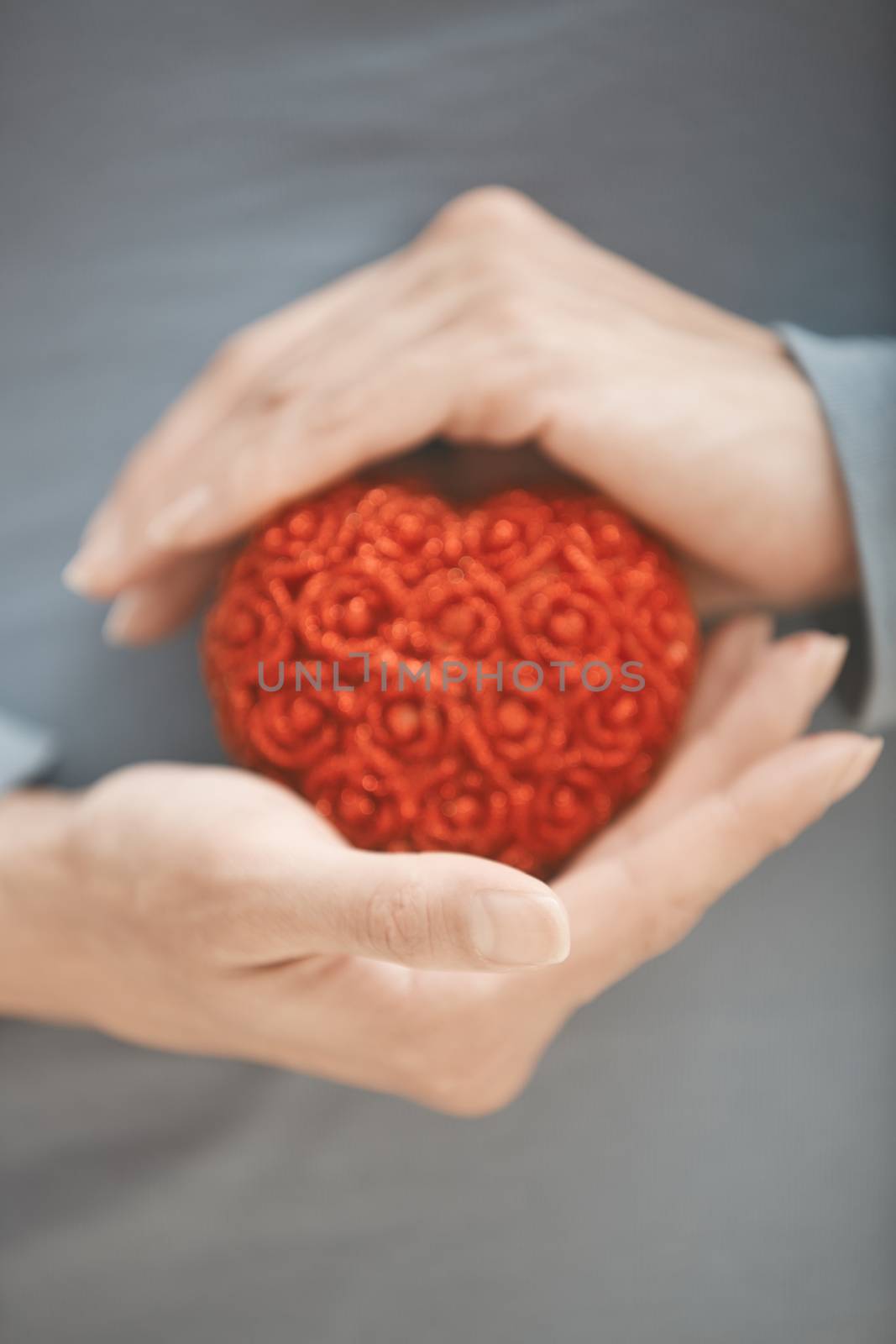 Woman hands holding red sweetheart. Vertical photo