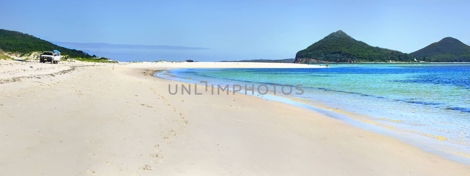 Beautiful blue waters and almost white sands at Jimmys Beach Hawks Nest panorama with Mt Tomaree in view.   A popular place for fishermen and lovely place to swim.