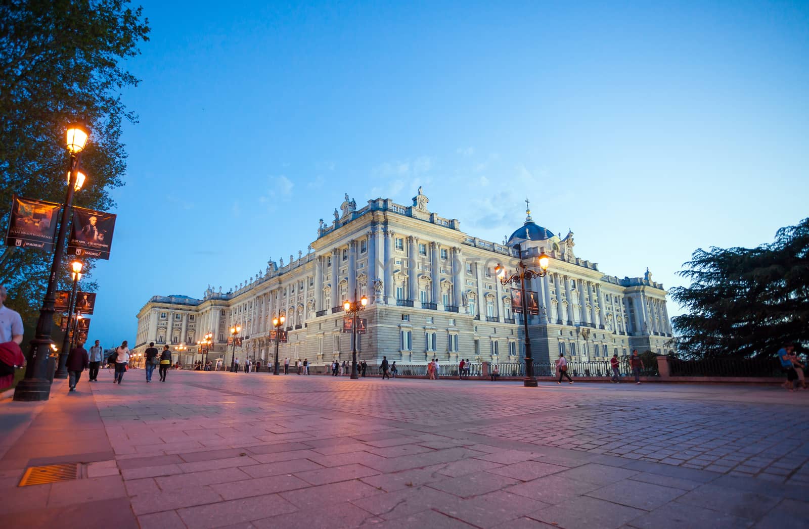 Madrid, Spain - May 10, 2012: Royal palace (Palacio Real de Madrid) with visiting tourists on a spring night in Madrid, Spain