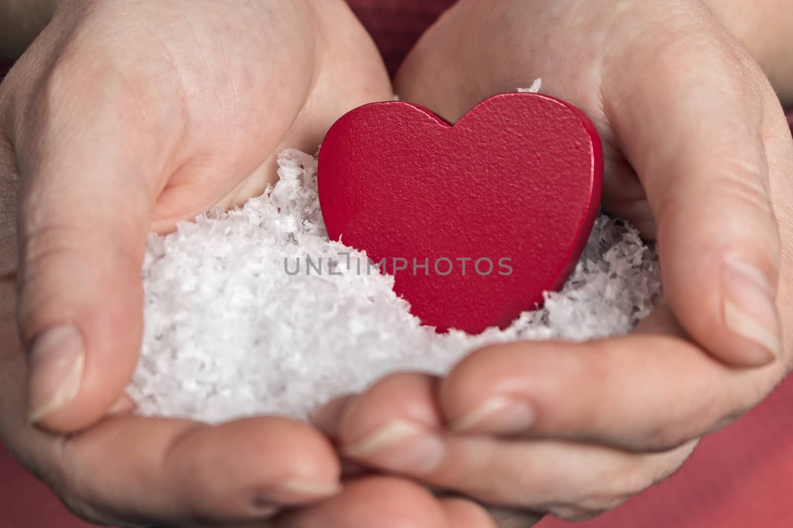 Open hands as a sign of love with red heart