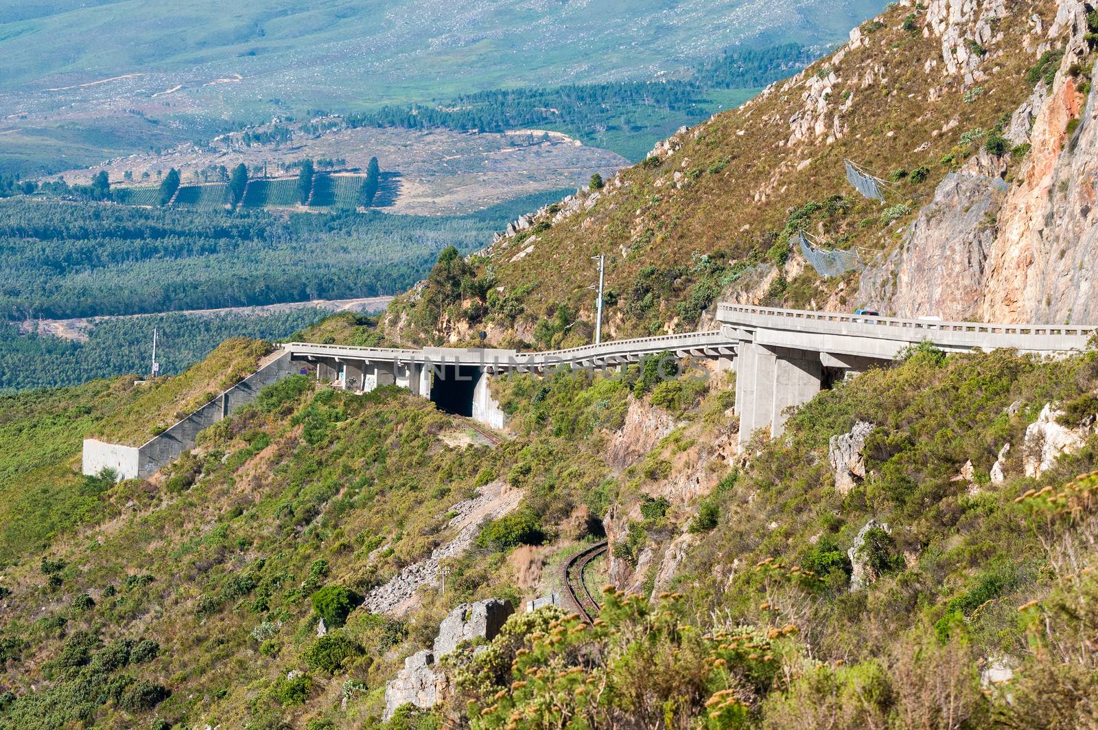 View of Sir Lowreys Pass in the Hottentots-Holland mountains near Somerset West, South Africa. The bridges over the old, unused roalroad is visible. Safety nets keep rockfalls away from the road
