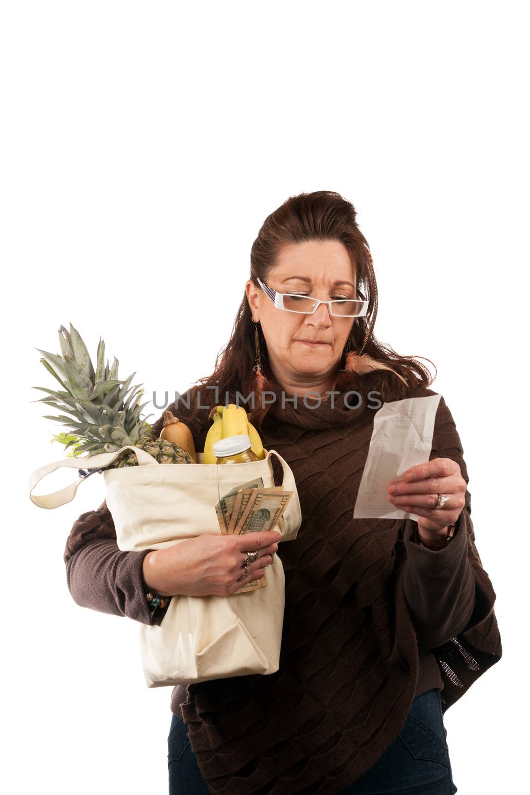 Middle aged woman carefully examining her register receipt reviewing her grocery shopping bill.