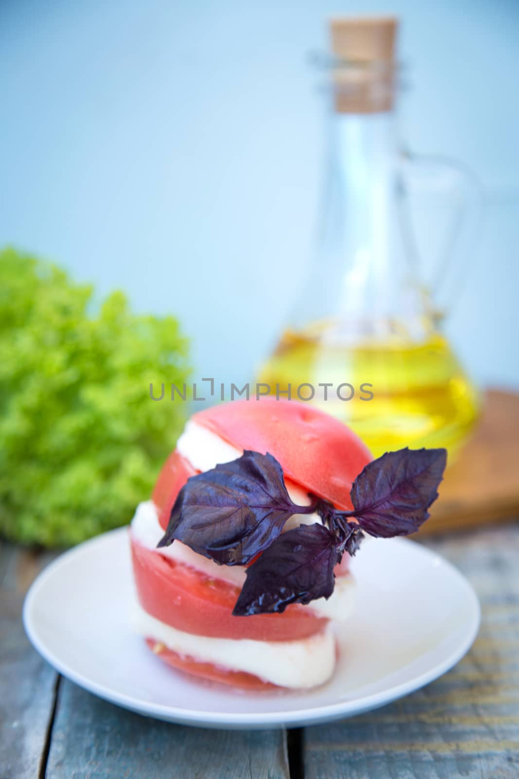 salad with mozzarella,tomatoes,dark basil on wooden retro background