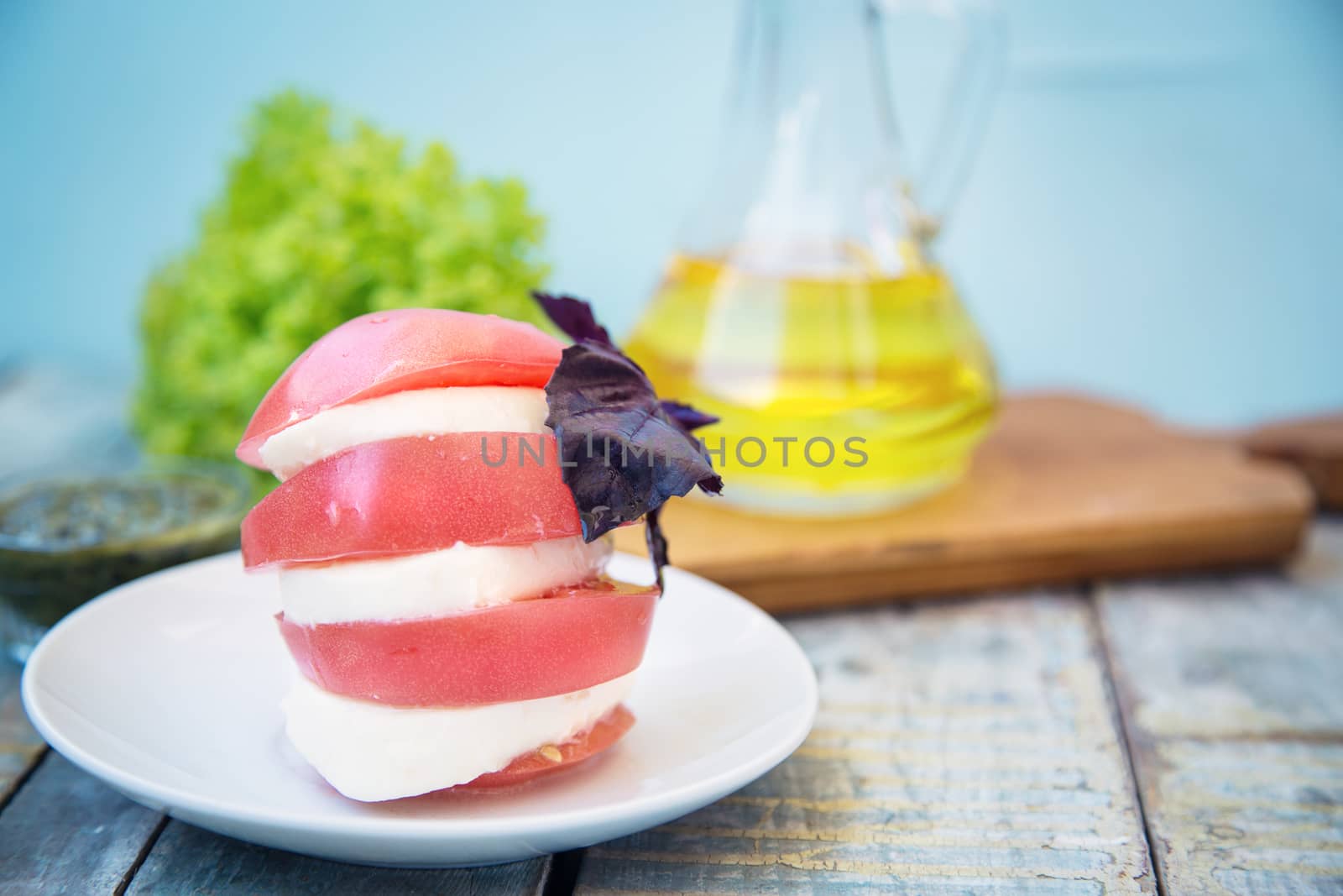 salad with mozzarella,tomatoes,dark basil on wooden retro background