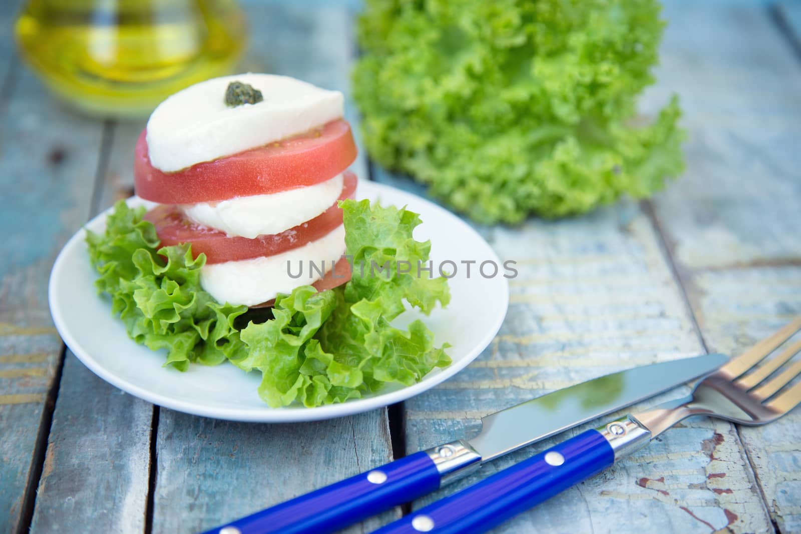 salad with mozzarella,tomatoes,dark basil on wooden retro background