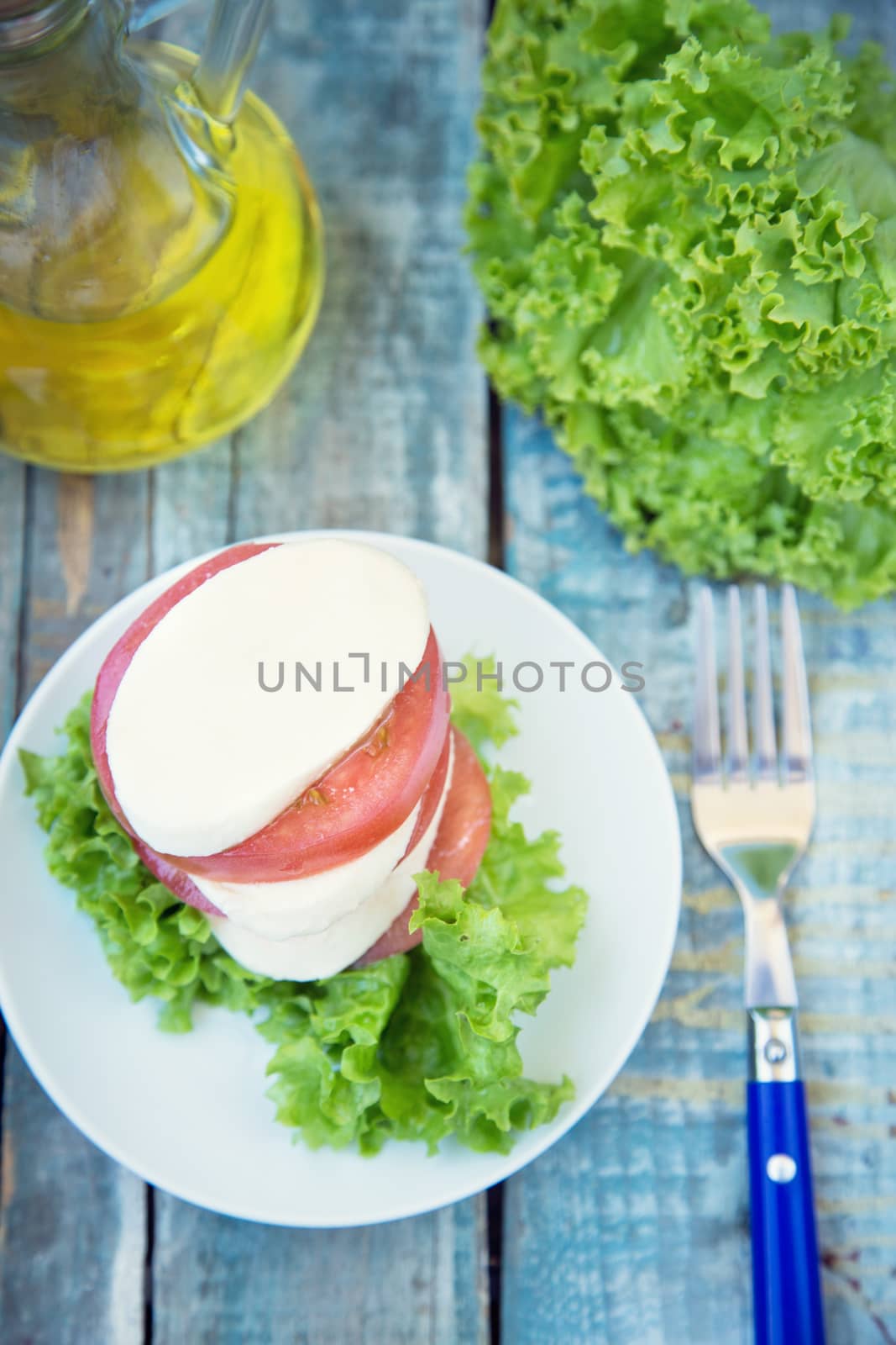 salad with mozzarella,tomatoes,dark basil on wooden retro background